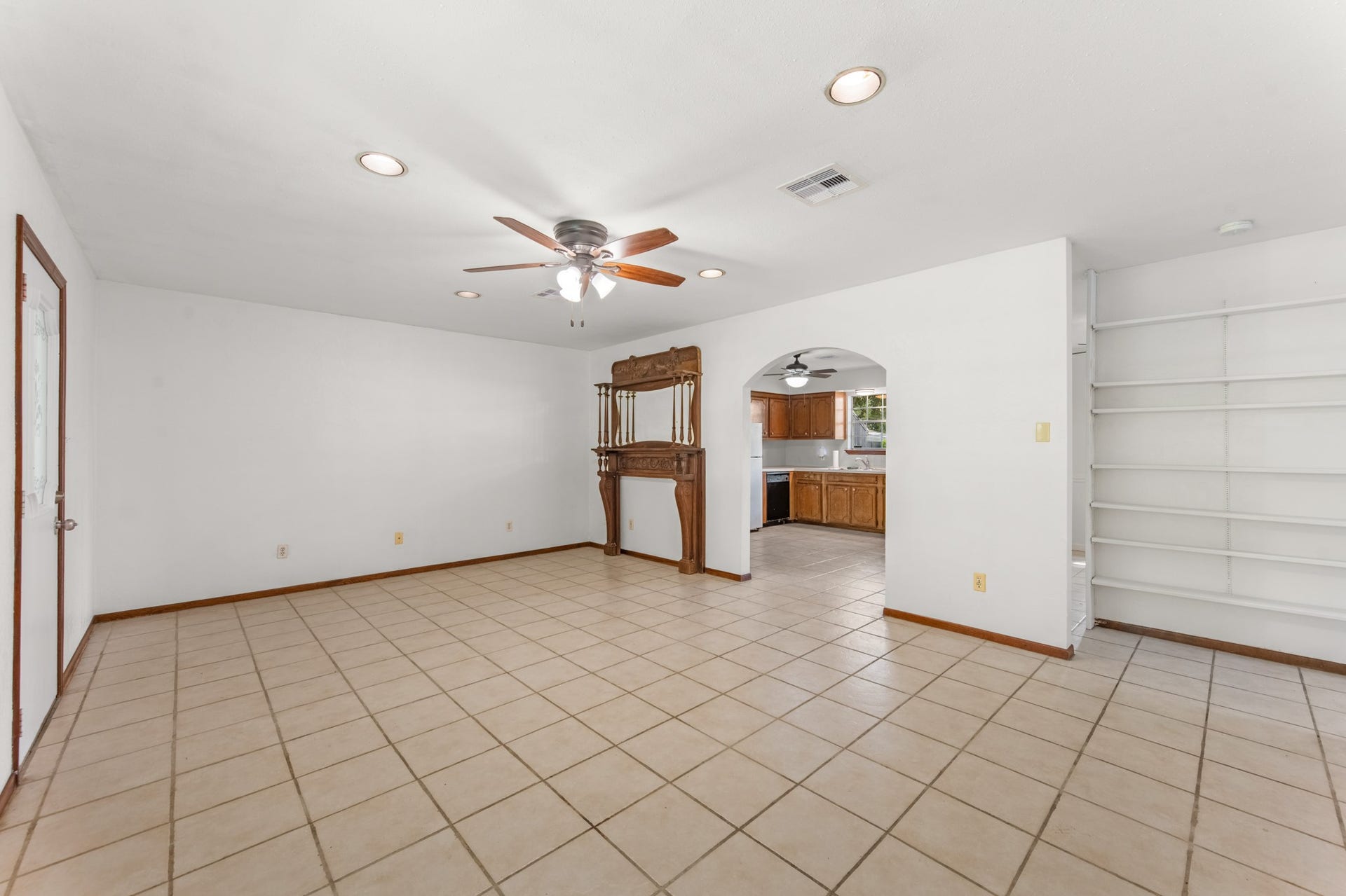 11325 32nd Street, Santa Fe, TX 77510 An arched opening connects the living room to the kitchen, creating a welcoming flow between the home's main gathering spaces. Built-in shelving provides additional display and storage options.