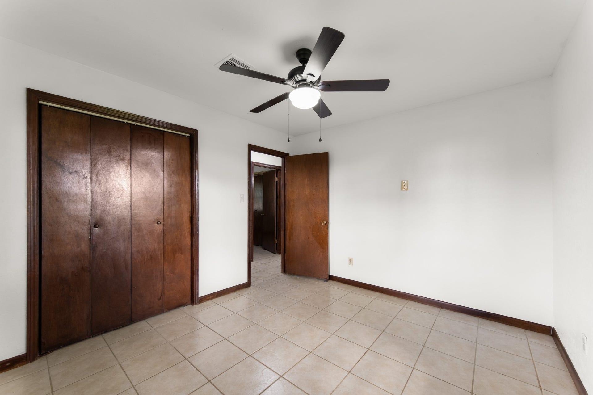 11325 32nd Street, Santa Fe, TX 77510 Another perspective highlighting the bedroom's generous closet space, rich wood trim, tile flooring, and ceiling fan.