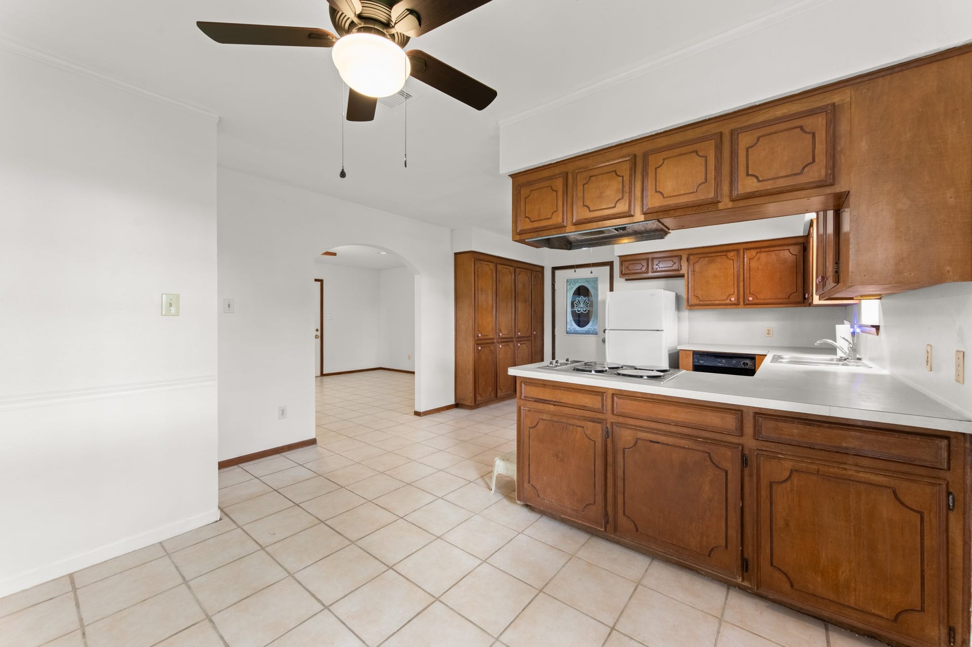 11325 32nd Street, Santa Fe, TX 77510 The dining area flows conveniently into the kitchen, featuring warm wood cabinetry, a breakfast bar, and an arched opening connecting to the adjacent living space.