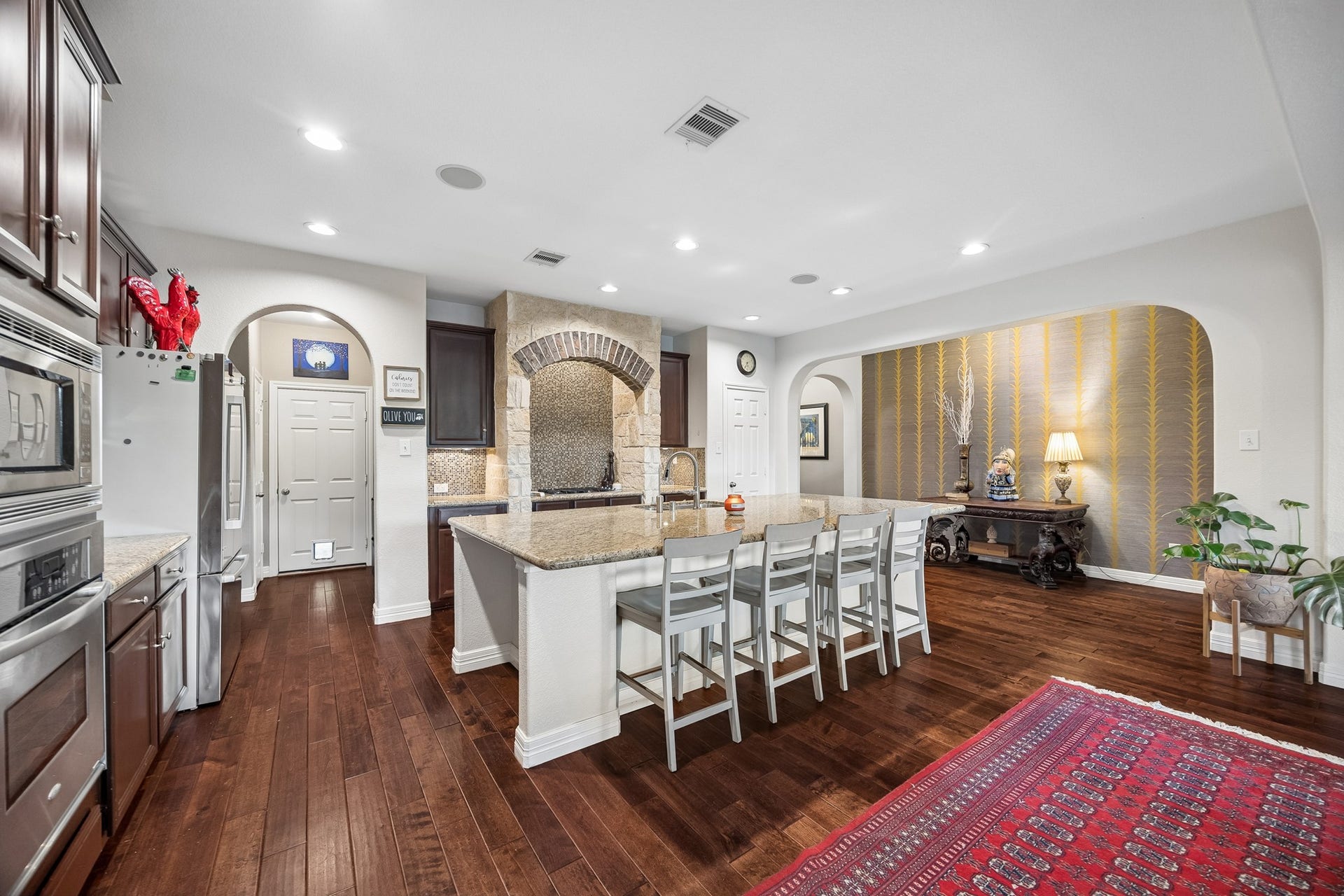 3102 London Lane, Missouri City, TX 77459 The open concept kitchen / living floorplan accomodates a large group for entertaining. The feature wall with designer wallpaper adds a custom touch.