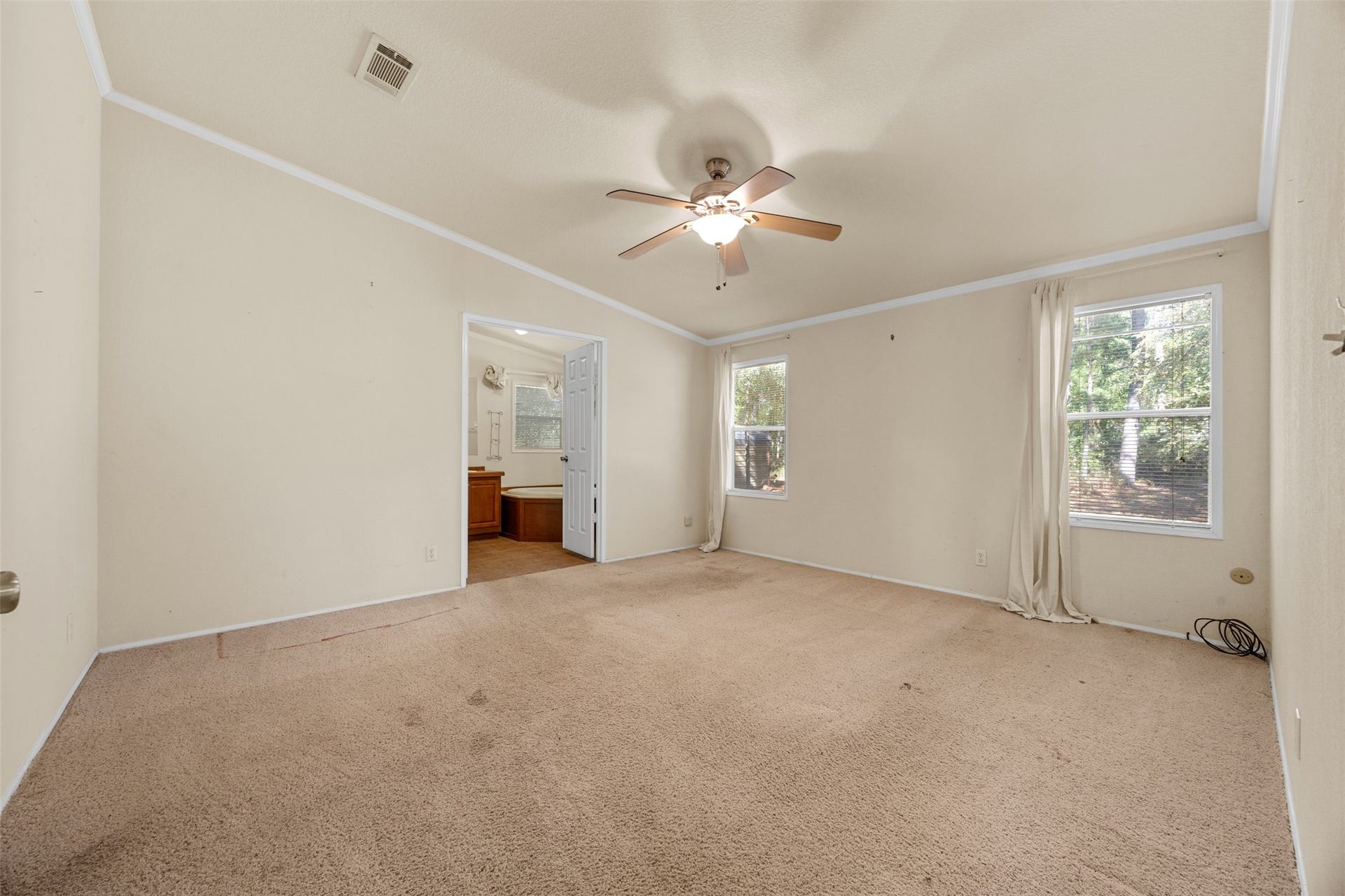 9944 Chestnut Court, Montgomery, TX 77316 The spacious primary bedroom features a vaulted ceiling, abundant natural light from two windows, and plenty of room for a comfortable seating area. An adjoining private bathroom completes the suite.