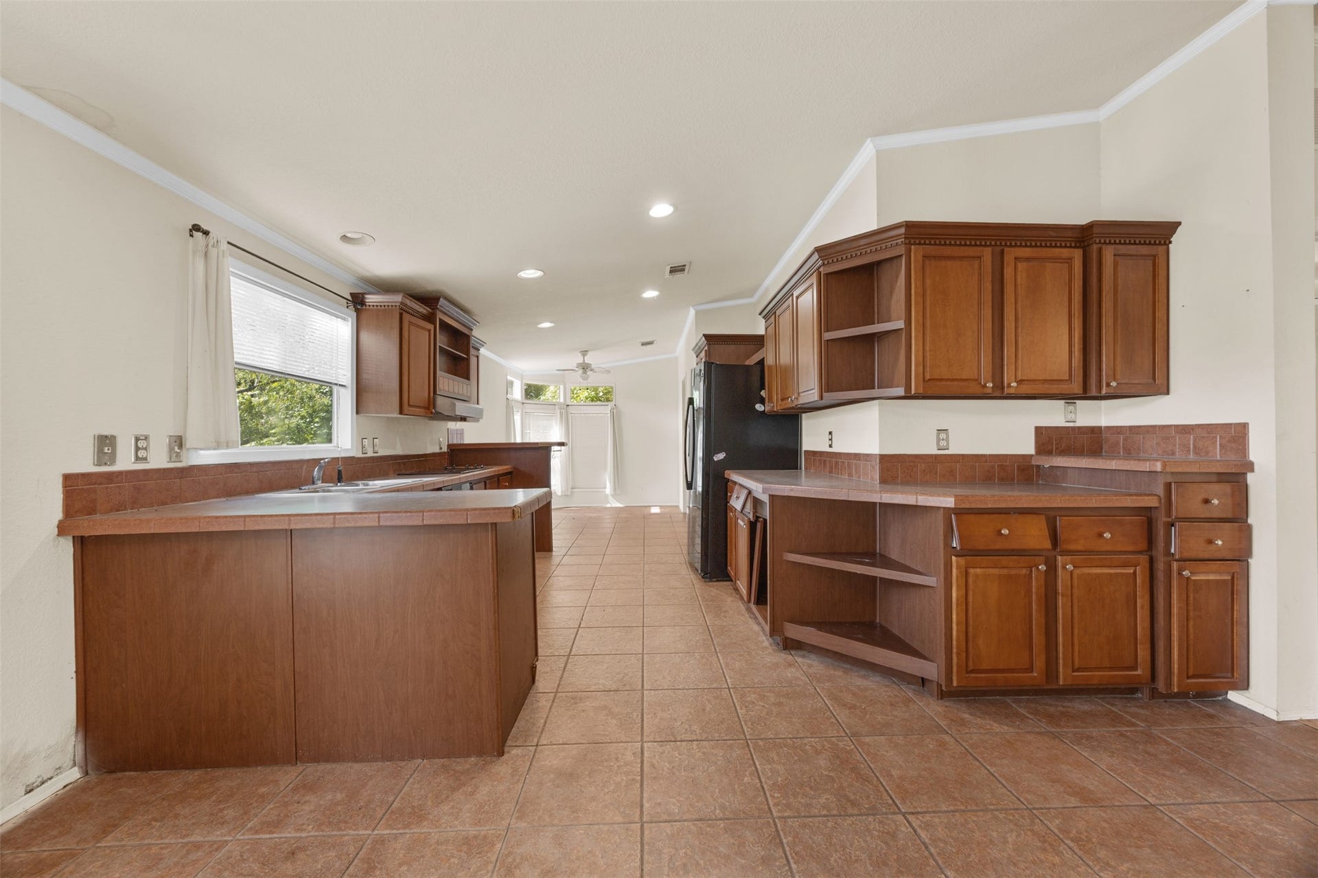 9944 Chestnut Court, Montgomery, TX 77316 The spacious kitchen features abundant cabinetry, generous counter space, and open shelving for additional storage or display. Natural light fills the space, offering a functional layout with plenty of potential for future updates.