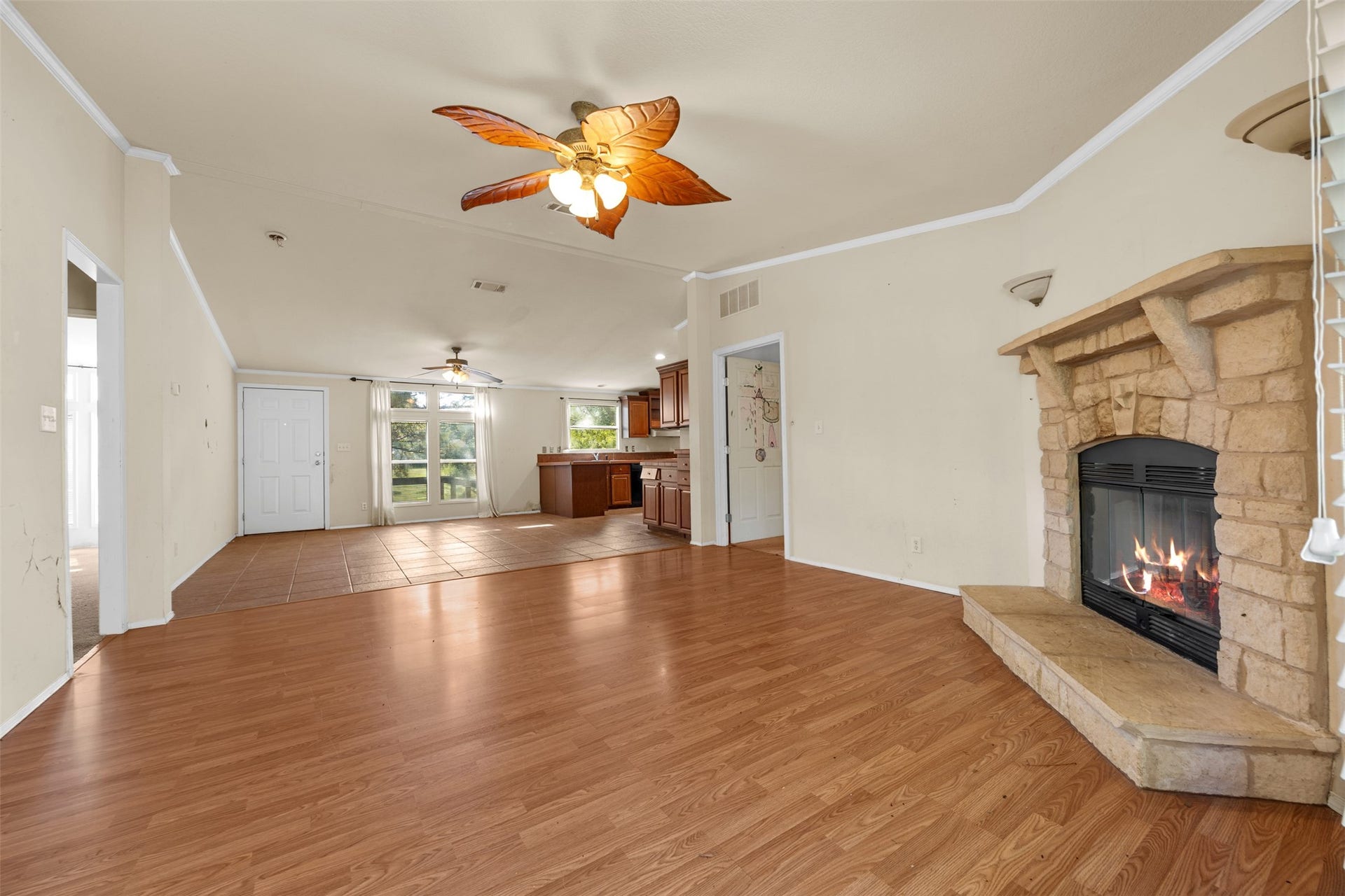 9944 Chestnut Court, Montgomery, TX 77316 Another view of the spacious living area highlights the beautiful stone fireplace, vaulted ceiling, and seamless connection to the kitchen and dining spaces. An inviting layout with plenty of room to make it your own.