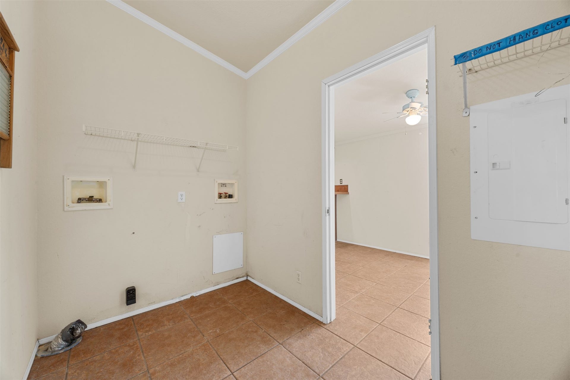 9944 Chestnut Court, Montgomery, TX 77316 Dedicated laundry room with washer and dryer connections, built-in shelving, and tile flooring, offering a practical space for everyday household needs.