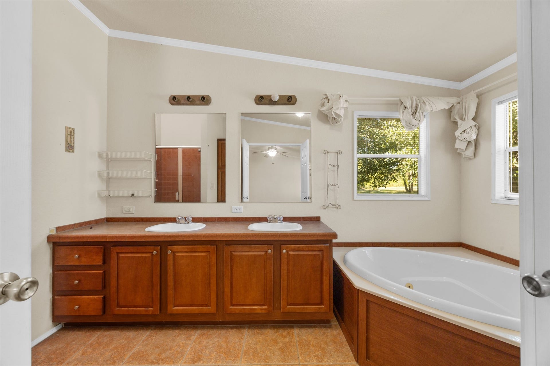 9944 Chestnut Court, Montgomery, TX 77316 The primary bathroom offers a functional layout with dual vanities, generous cabinet storage, and a corner soaking tub, providing a great foundation for future updates.