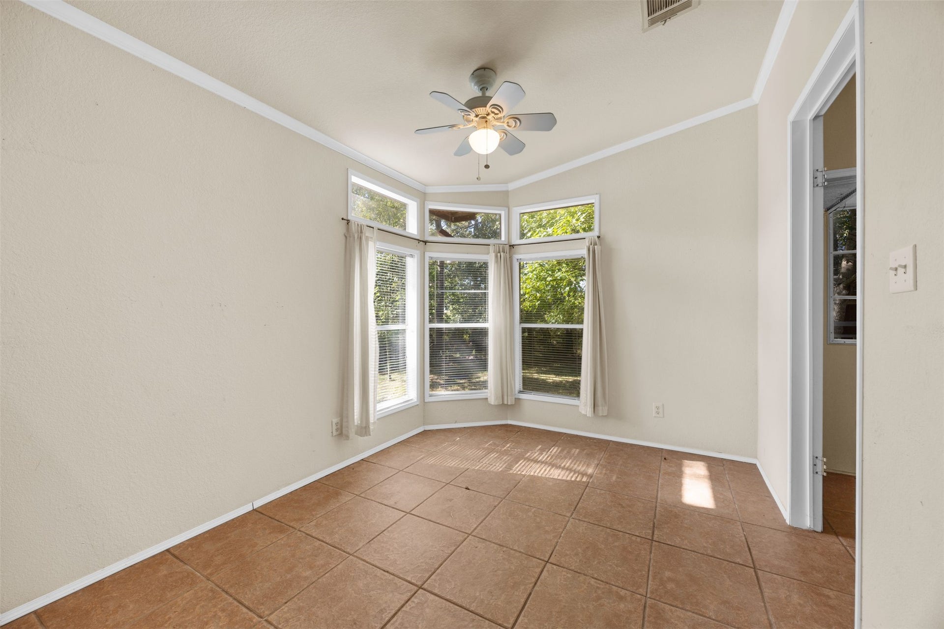 9944 Chestnut Court, Montgomery, TX 77316 The bright breakfast room features a beautiful wall of windows overlooking the surrounding greenery, creating a welcoming space to enjoy morning coffee or casual meals with a view.