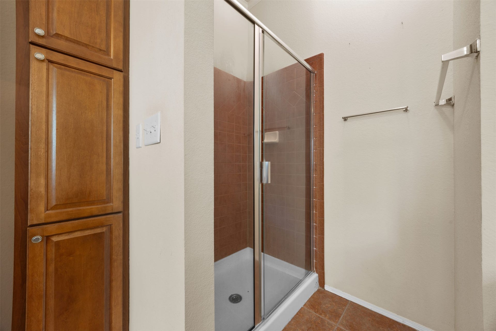 9944 Chestnut Court, Montgomery, TX 77316 The primary bathroom also includes a separate glass-enclosed shower with tile surround and built-in linen cabinetry for additional storage.