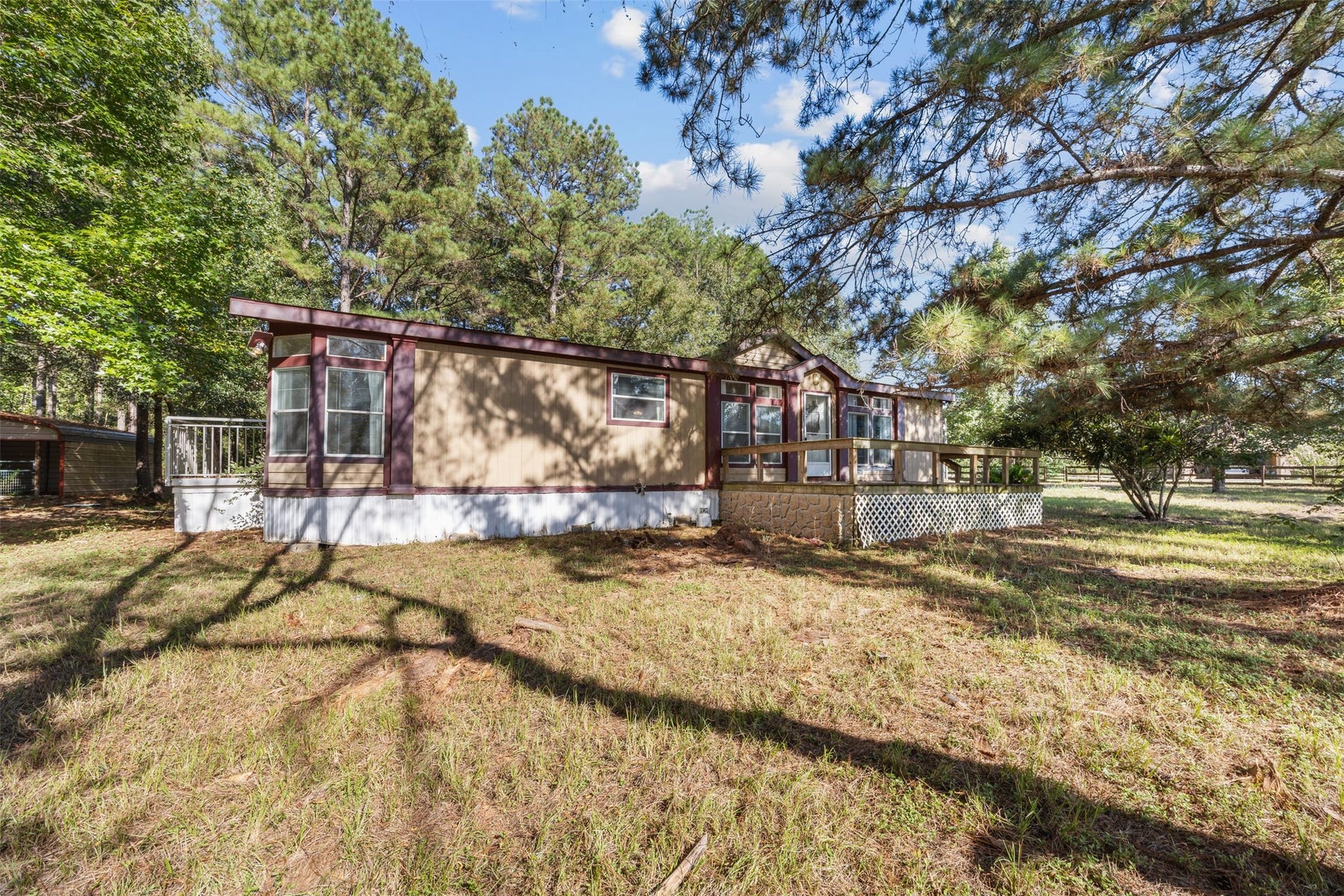9944 Chestnut Court, Montgomery, TX 77316 A wider view of the home highlights its distinctive exterior, multiple windows, and elevated deck, offering a closer look at the property's layout and character.