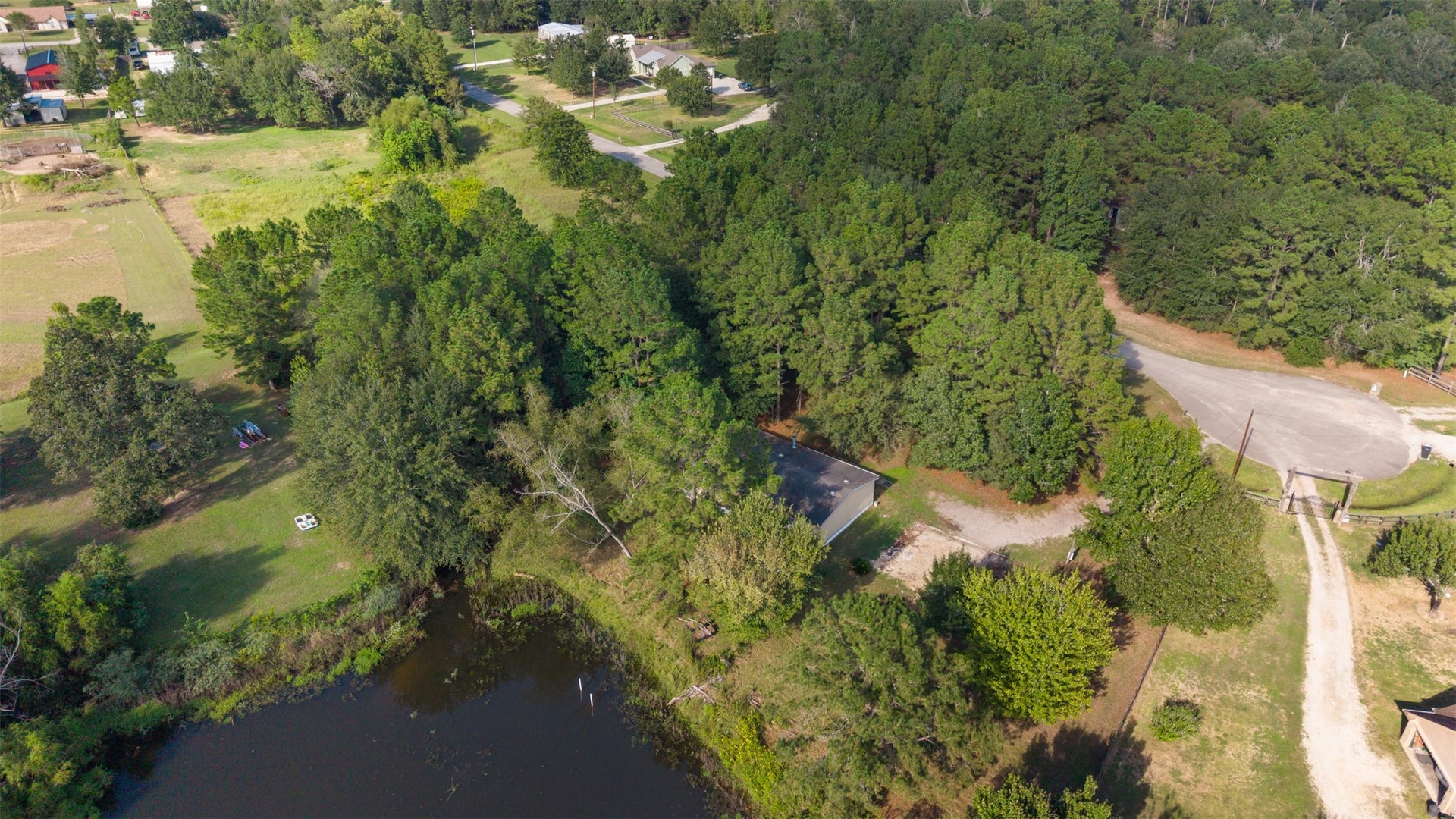 9944 Chestnut Court, Montgomery, TX 77316 A birds-eye view highlights the property's wooded setting, pond frontage, and generous outdoor space, offering a wonderful opportunity to enjoy country living surrounded by nature.