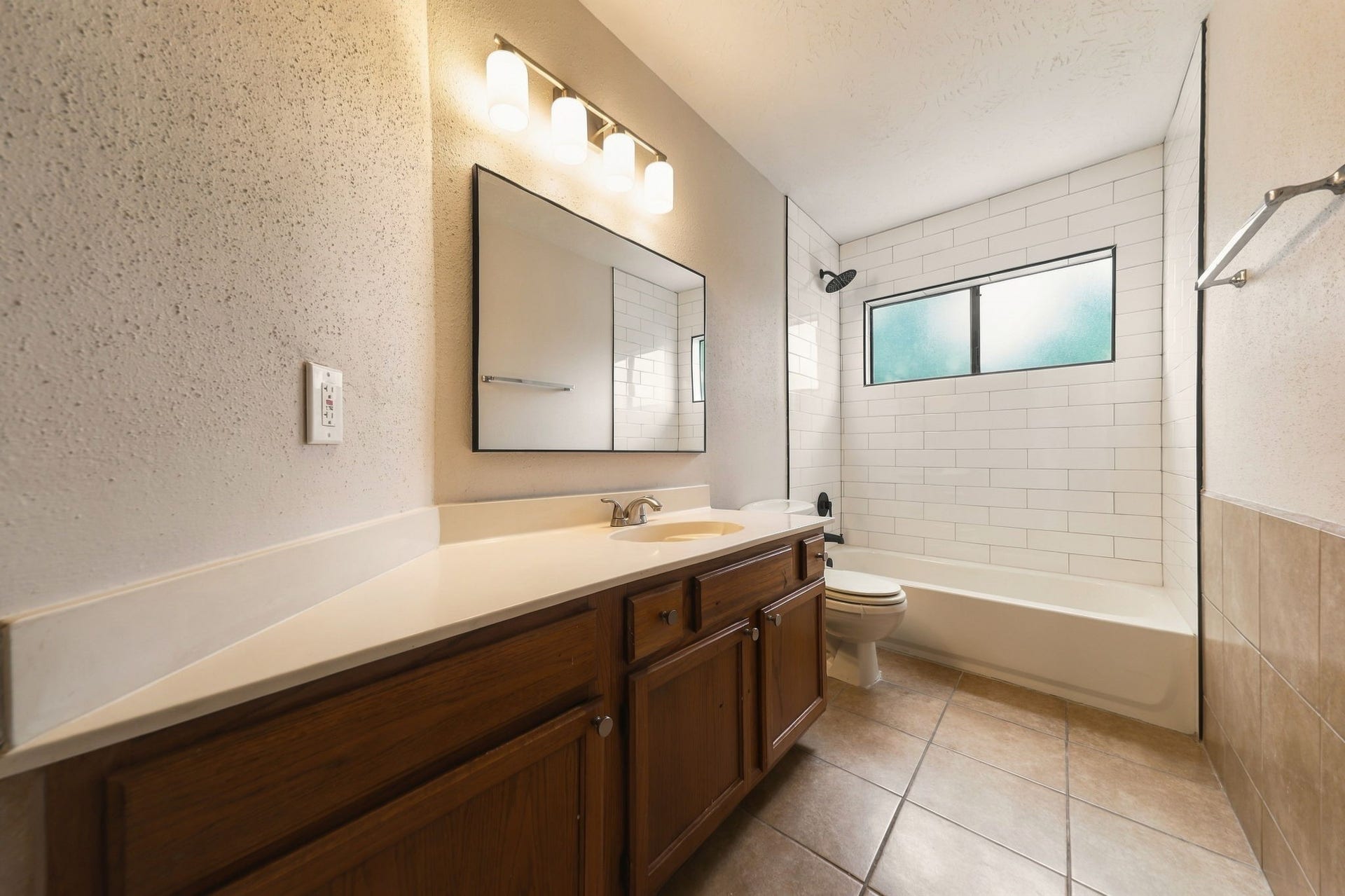 Large hall bath between Bedrooms #2 and #3 with new shower tile, light fixture and mirror.
