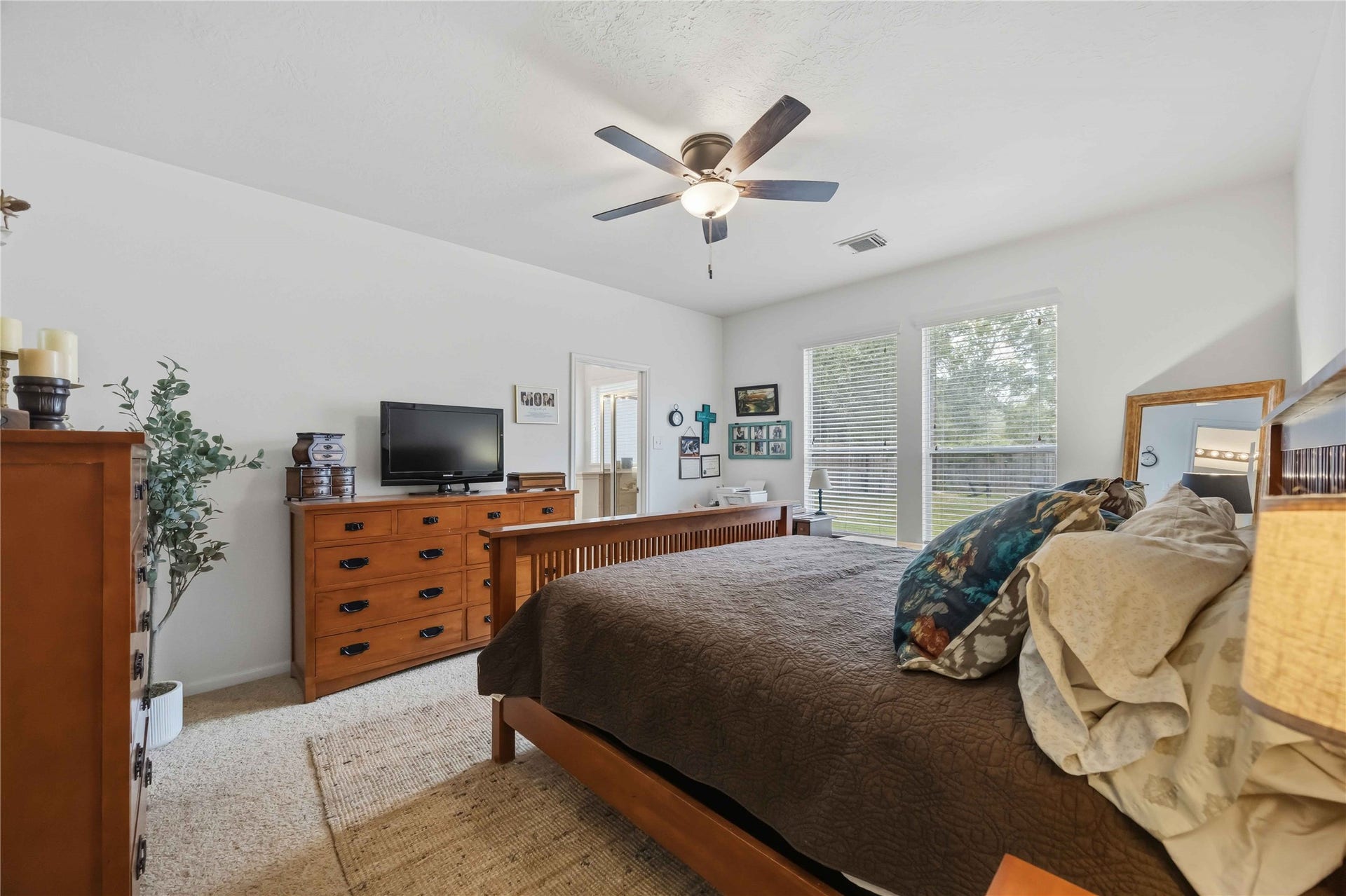 11415 English Rose Trail, Missouri City, TX 77459 Spacious primary bedroom with two large windows overlooking the backyard and an adjoining private bathroom.