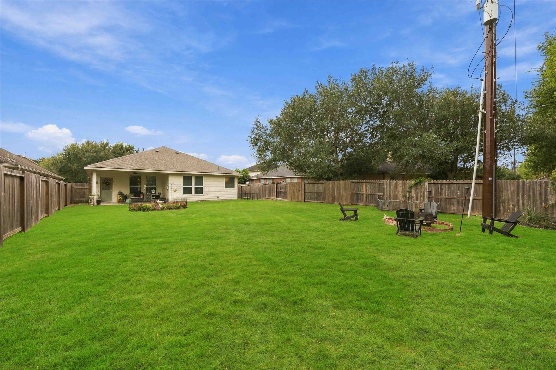 11415 English Rose Trail, Missouri City, TX 77459 Wide backyard view highlighting the substantial lawn area and designated outdoor gathering space.