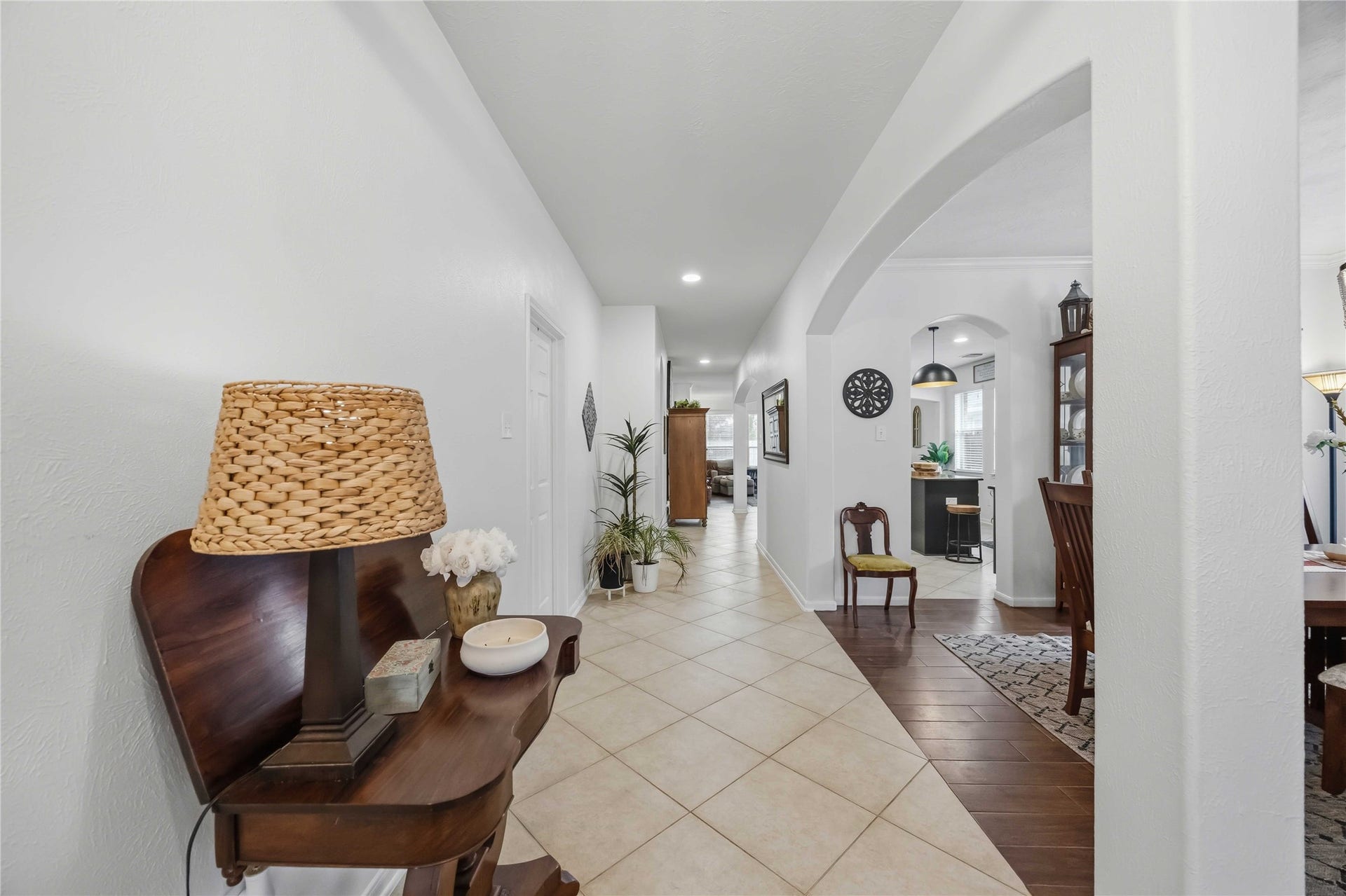 11415 English Rose Trail, Missouri City, TX 77459 Extended entry hallway featuring neutral tile flooring and arched openings connecting the living spaces.