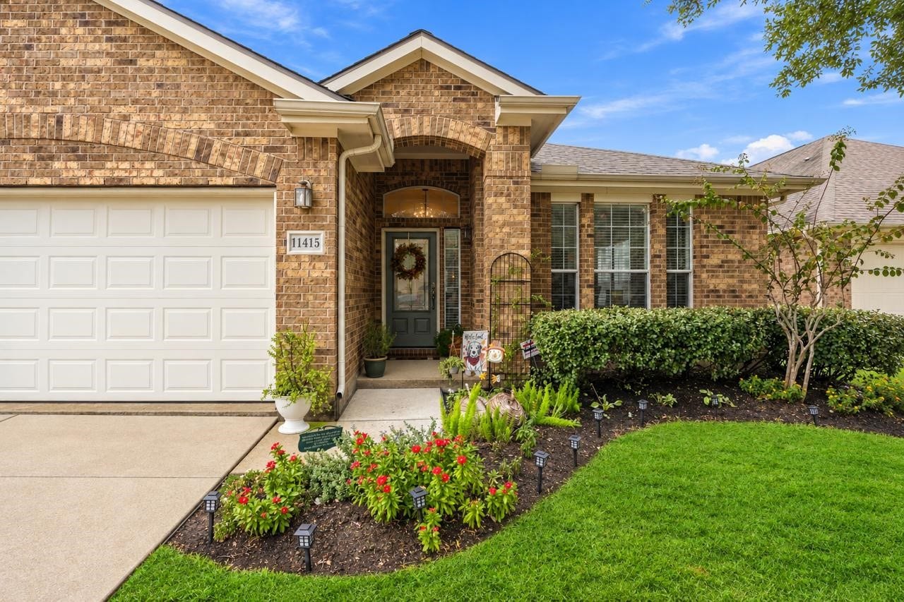 11415 English Rose Trail, Missouri City, TX 77459 Covered front entry framed by classic brickwork, landscaped flower beds, and large windows.