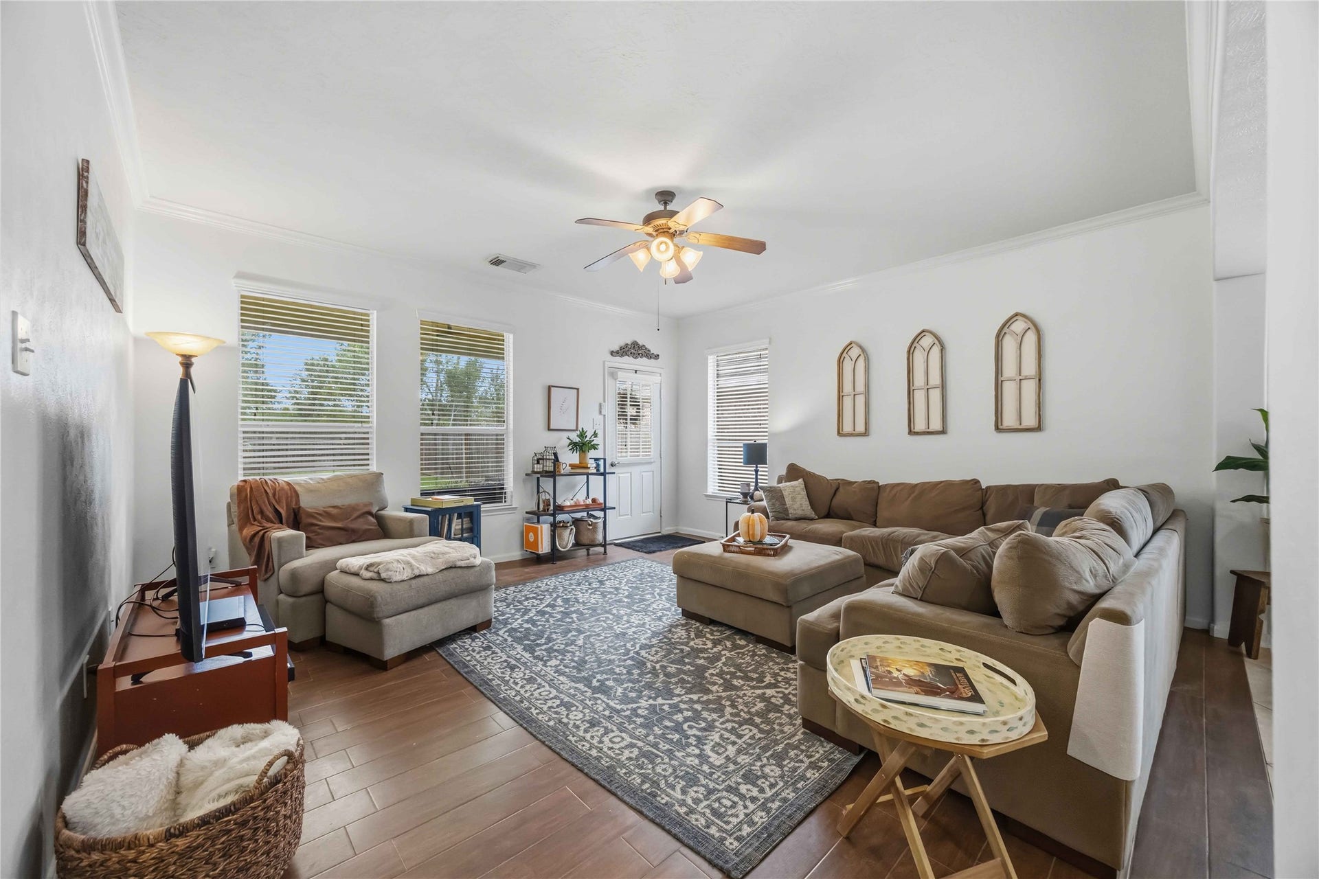 11415 English Rose Trail, Missouri City, TX 77459 Spacious family room featuring wood-look tile flooring, crown molding, and large windows that bring in natural light.