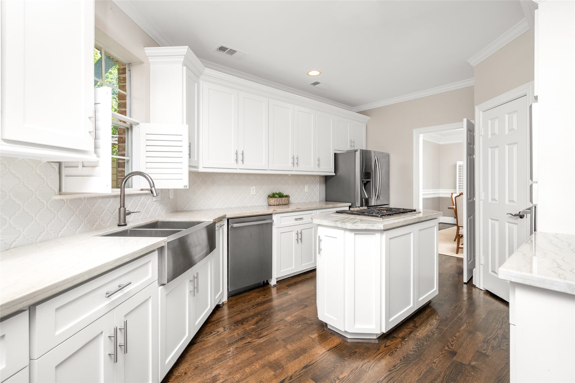 4312 Holt Street, Bellaire, TX 77401 Crown molding, abundant cabinet storage, and a window with plantation shutters bring light and detail.
