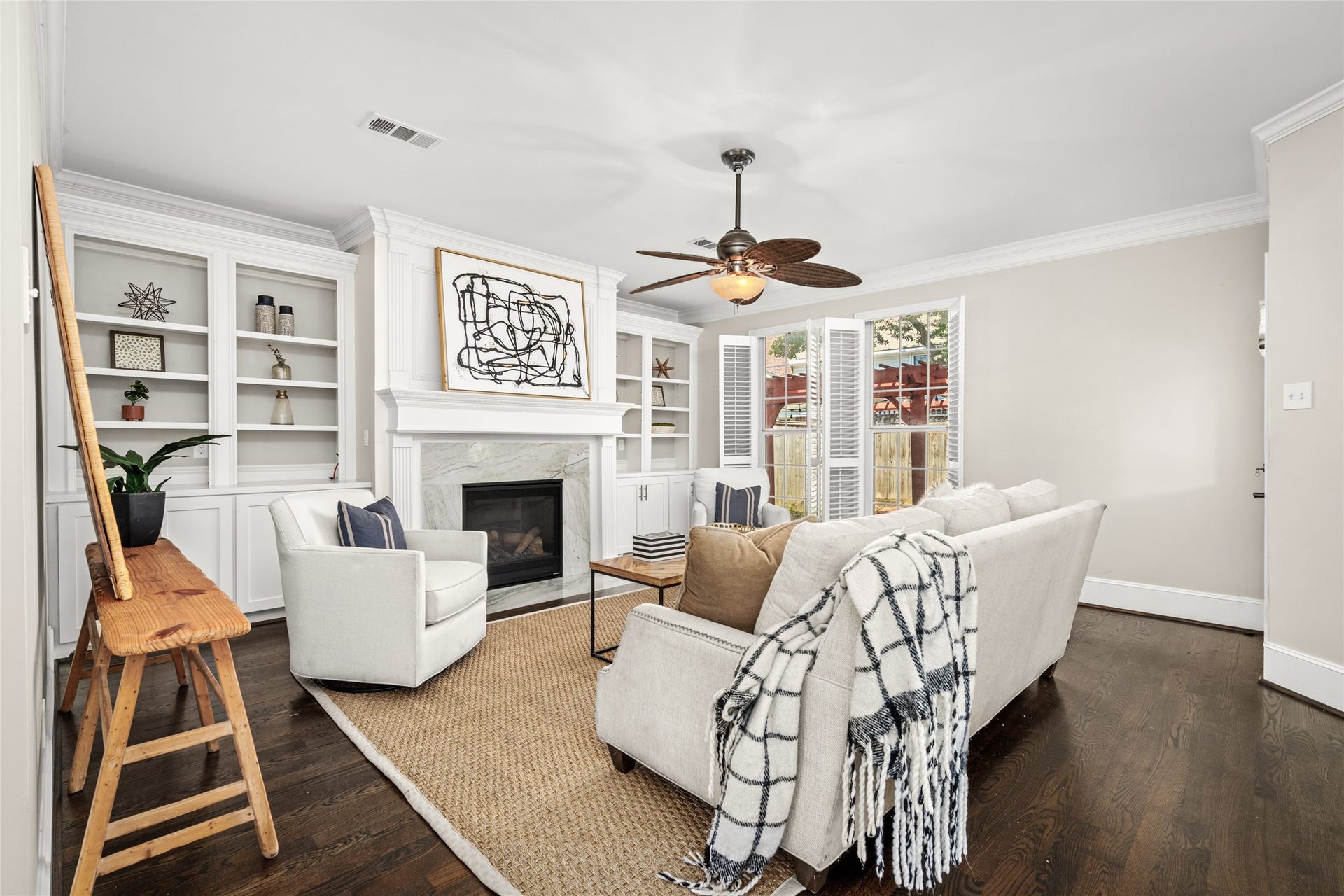 4312 Holt Street, Bellaire, TX 77401 Crown molding, a statement ceiling fan, and rich hardwoods blend ease with refined style.