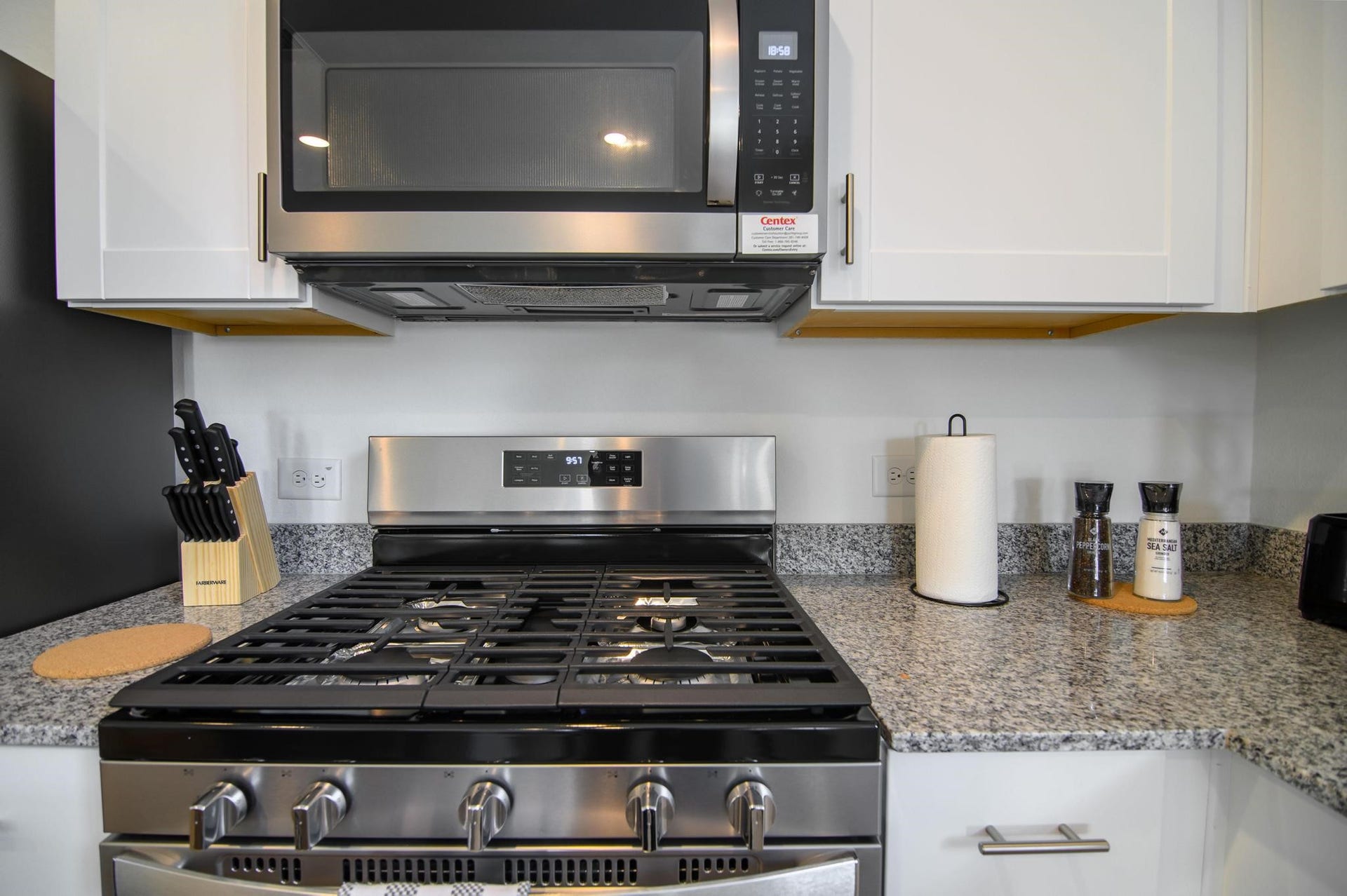Modern kitchen with sleek stainless steel appliances, granite countertops, and ample cabinet space, perfect for culinary enthusiasts.