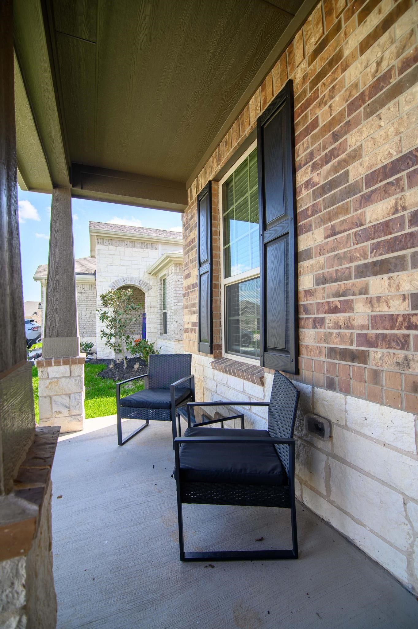 Charming front porch with comfortable seating, perfect for relaxing and enjoying the neighborhood view.