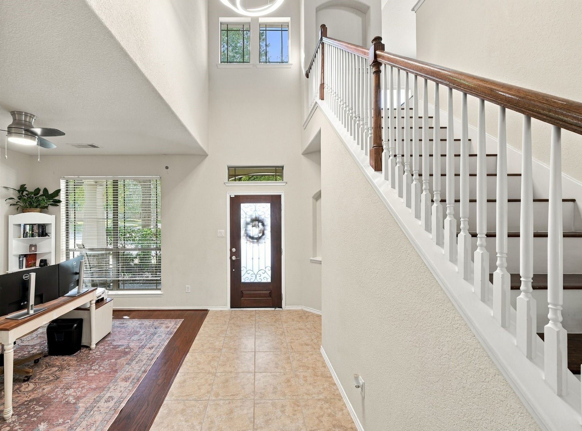 26037 Kings Mill Crest Drive, Kingwood, TX 77339 Elegant entryway with a high ceiling and abundant natural light, featuring a stylish staircase with wooden accents.