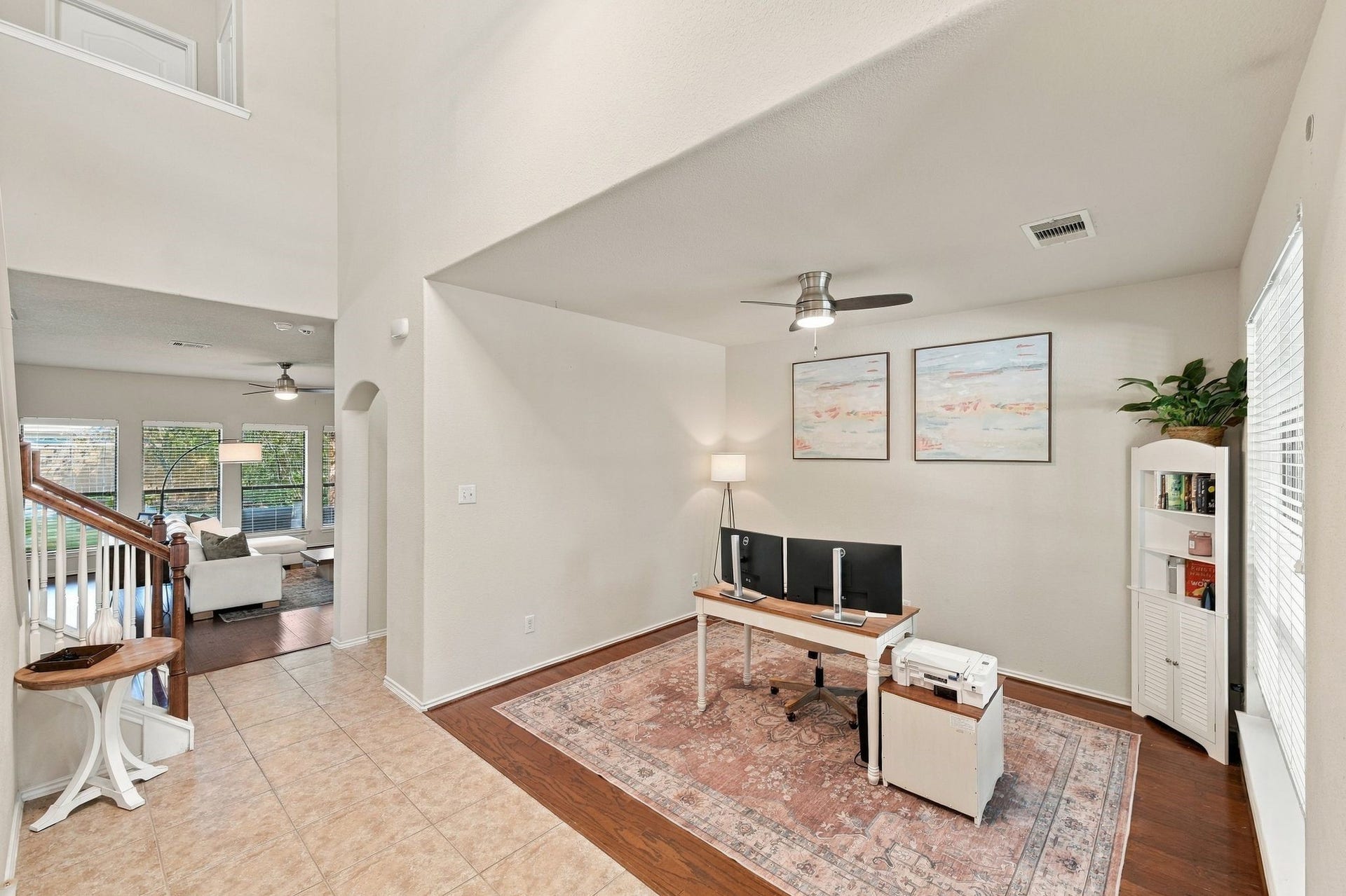 26037 Kings Mill Crest Drive, Kingwood, TX 77339 Spacious open-plan flex area with a office nook featuring elegant wood flooring and ample natural light, leading to a cozy living space ideal for relaxation.