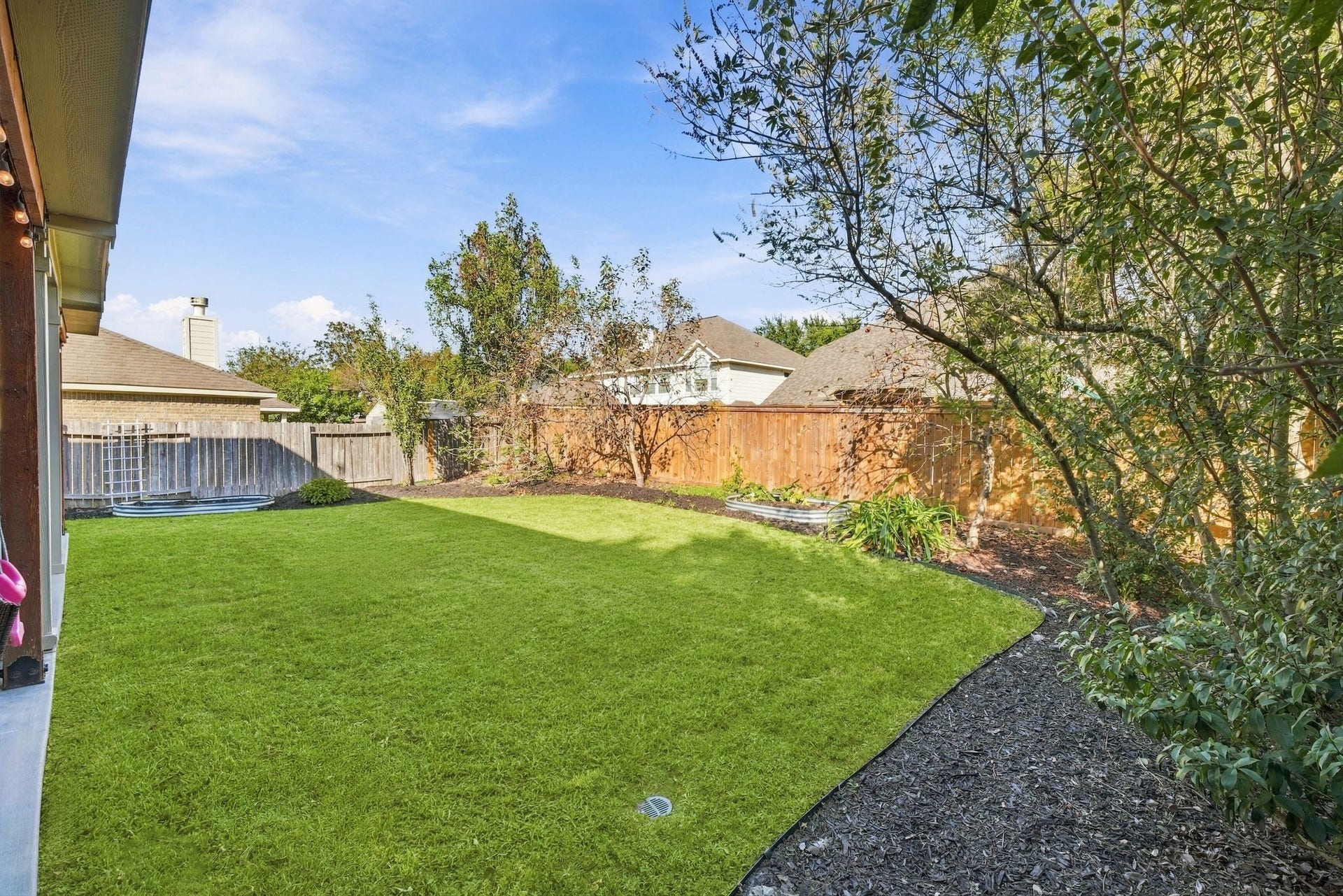 26037 Kings Mill Crest Drive, Kingwood, TX 77339 Spacious backyard with lush green lawn, mature trees, and wooden fencing, perfect for outdoor activities and privacy.