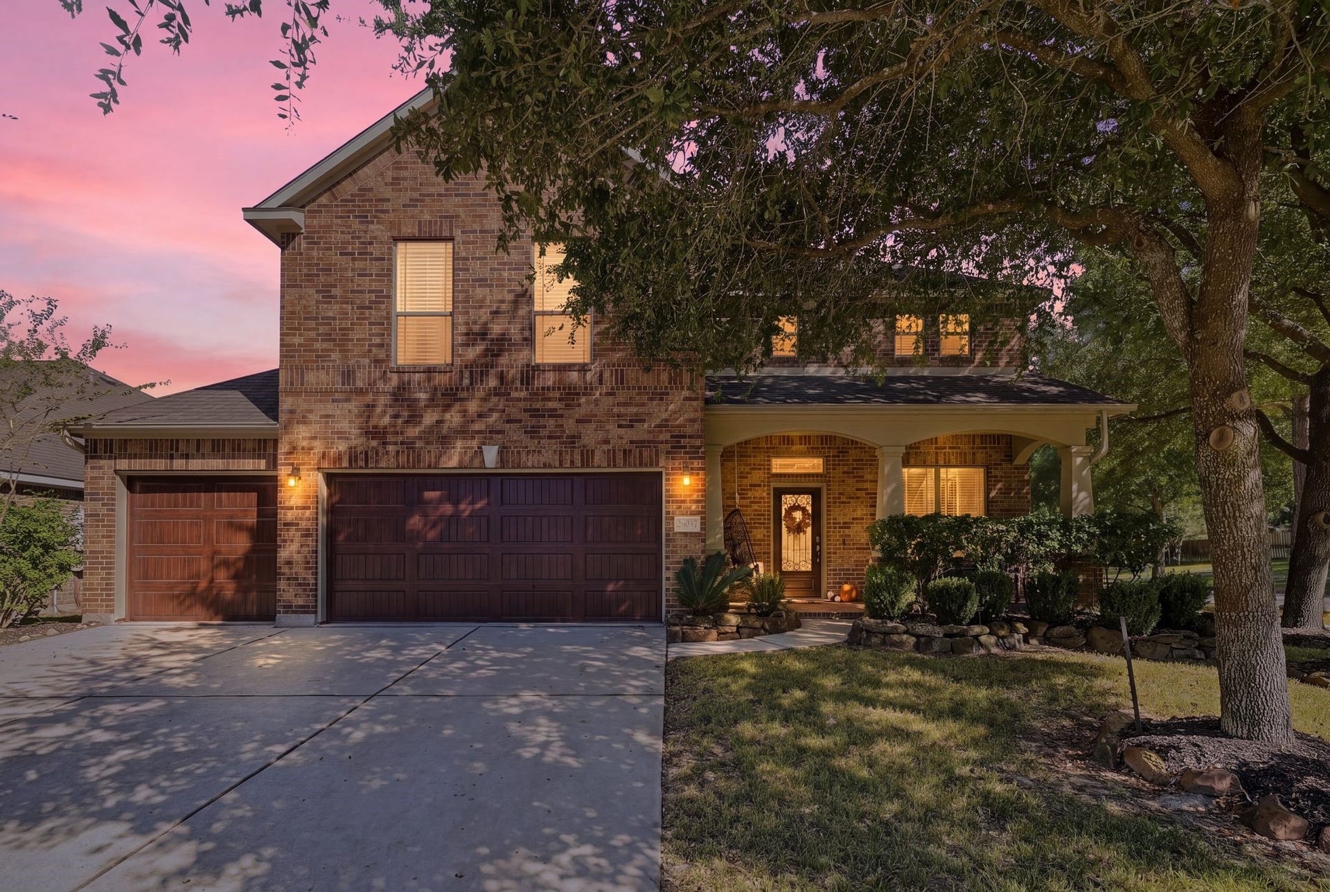 26037 Kings Mill Crest Drive, Kingwood, TX 77339 Stunning brick home with charming covered porch, nestled amidst mature trees and enhanced by a beautifully landscaped front yard.