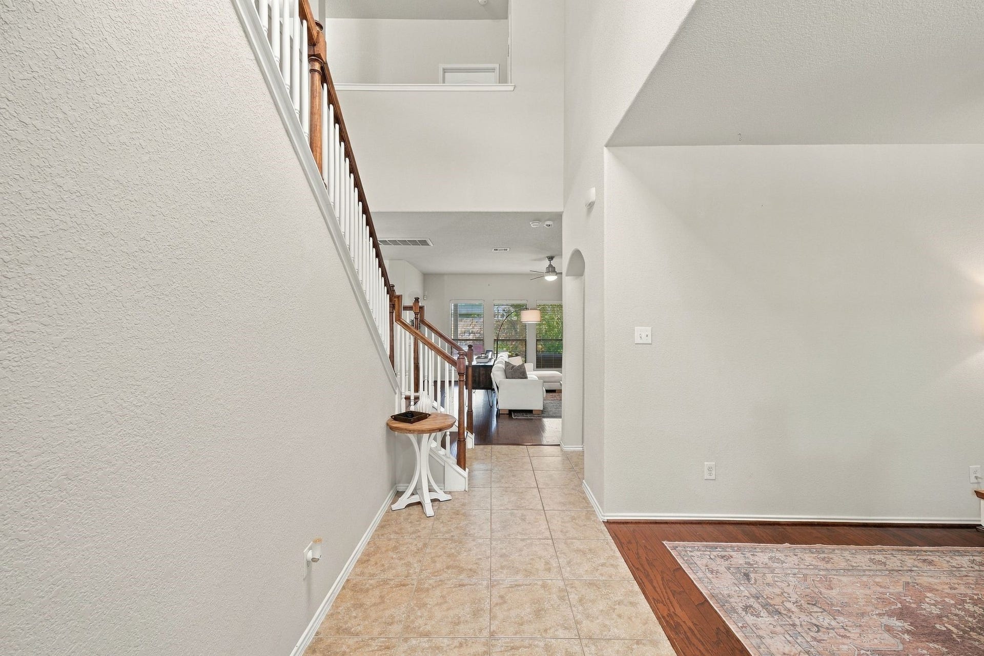 26037 Kings Mill Crest Drive, Kingwood, TX 77339 Bright and welcoming entryway with elegant tile flooring, leading to a spacious living area and featuring a stylish staircase.
