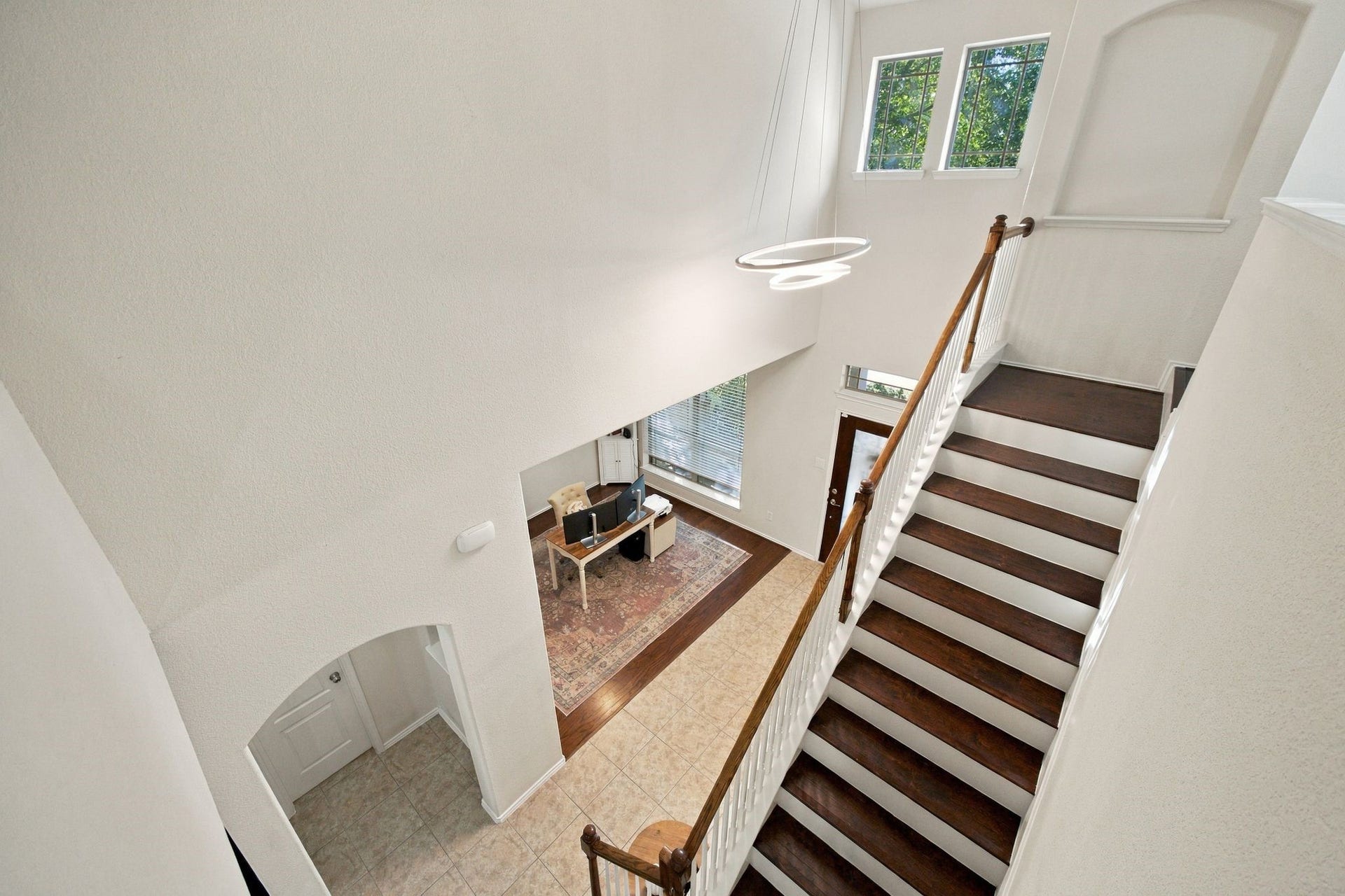 26037 Kings Mill Crest Drive, Kingwood, TX 77339 Elegant foyer with soaring ceilings and a grand staircase leading to the upper level, featuring modern lighting and abundant natural light from large windows.