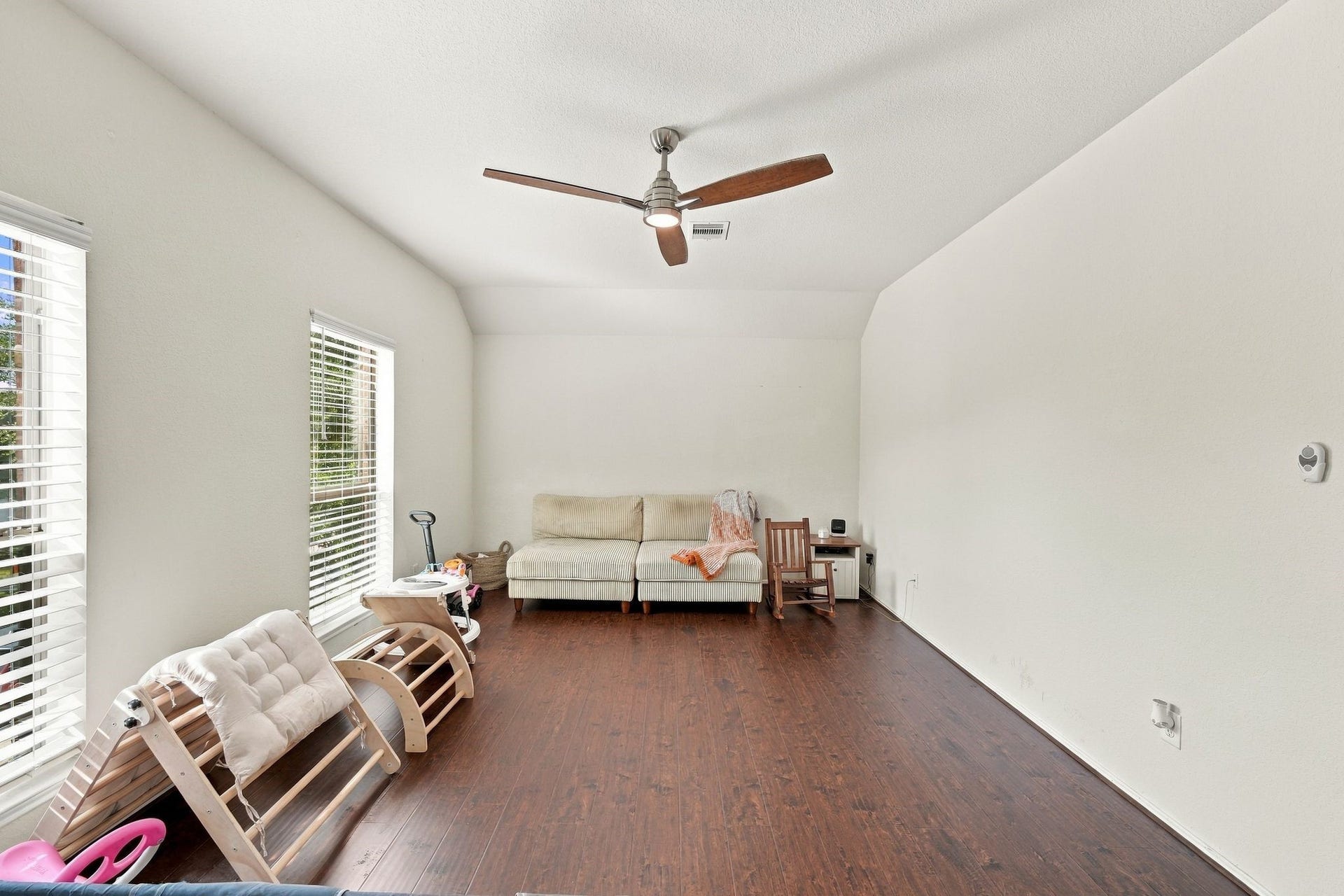 26037 Kings Mill Crest Drive, Kingwood, TX 77339 Bright and spacious living area with elegant wood flooring, abundant natural light from large windows, and a stylish ceiling fan. This can also be used as upstairs game room