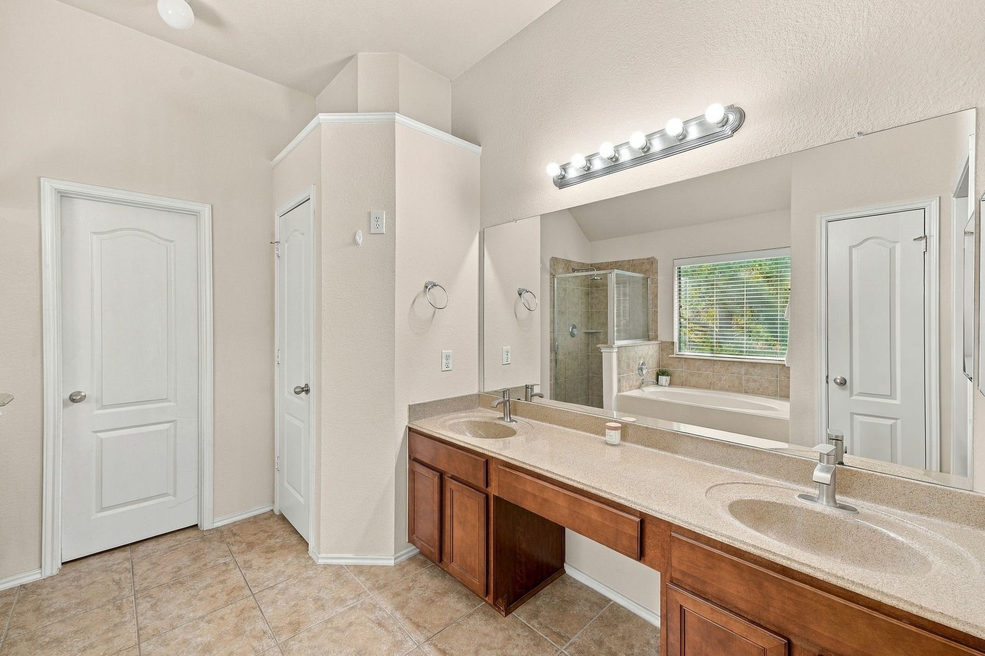 26037 Kings Mill Crest Drive, Kingwood, TX 77339 Spacious primary bathroom featuring a dual-sink vanity with elegant lighting, a large mirror, and a separate shower and bathtub for ultimate comfort.