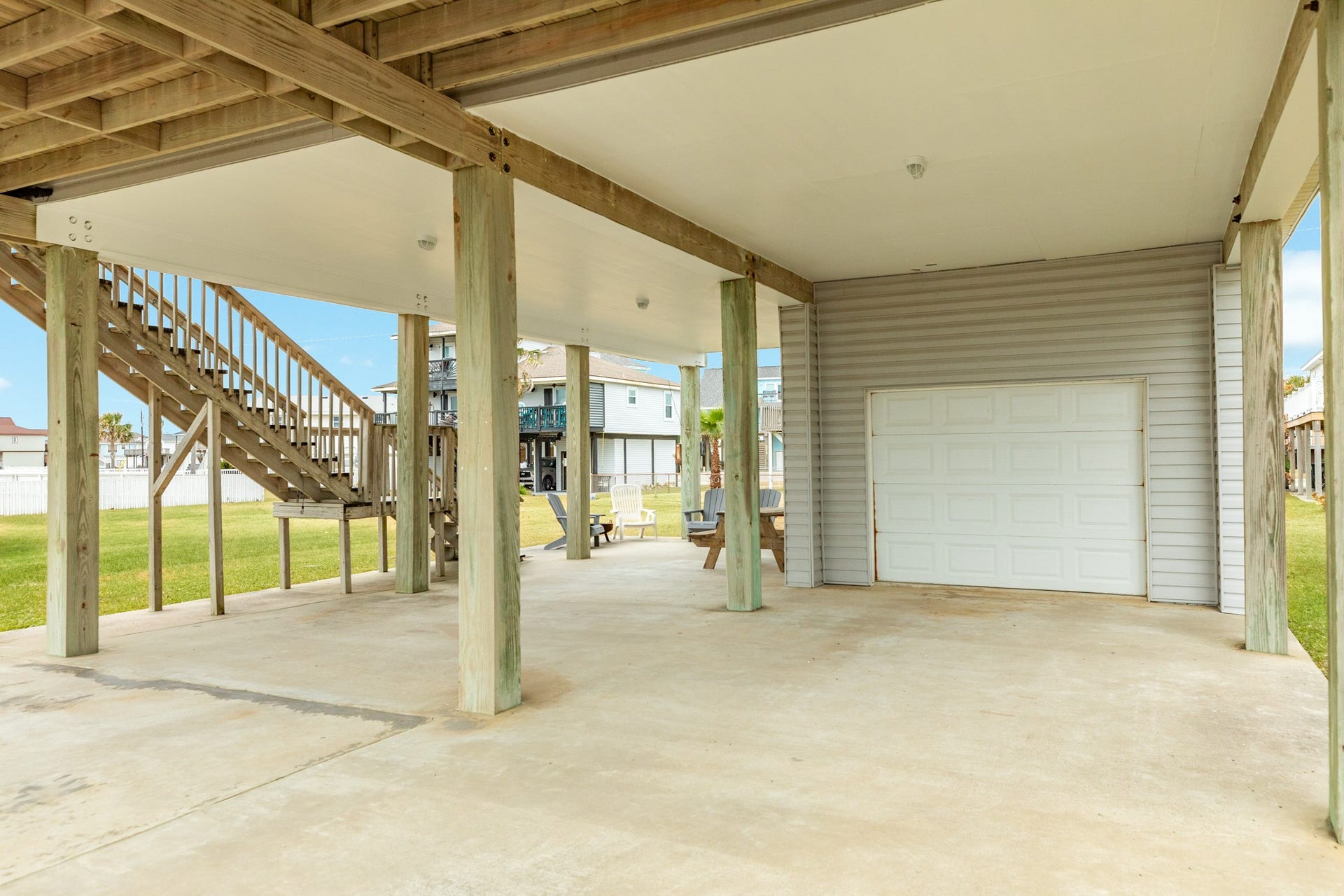 23012 Verano Drive, Galveston, TX 77554 View under home. Single car garage space, double wide & long driveway provides for plenty of parking and a side patio area.