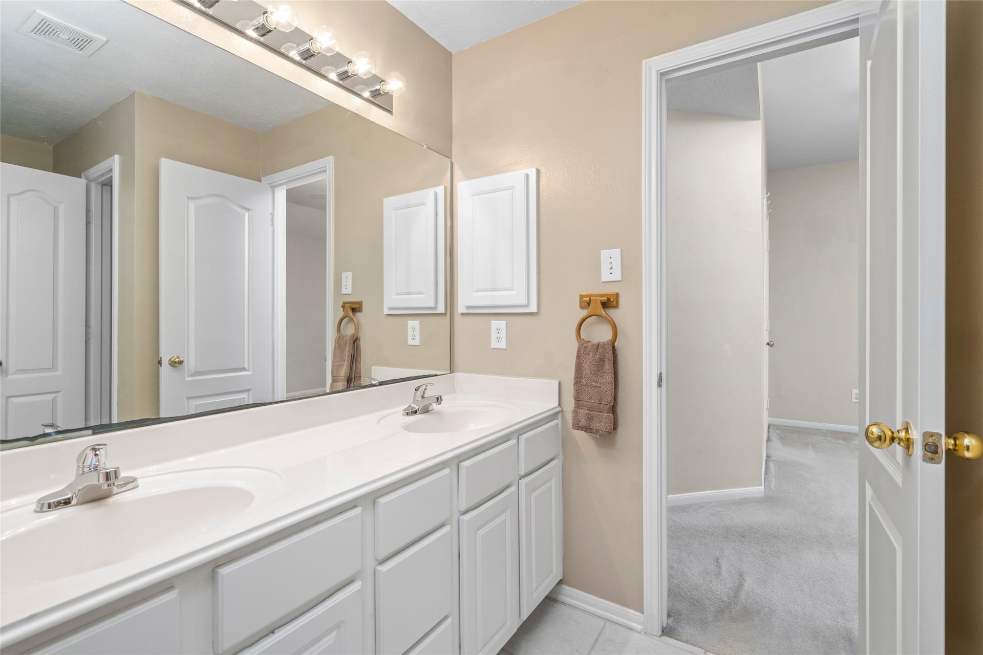 Well-appointed bathroom with dual-sink vanity, generous storage, and a functional layout serving the upstairs bedrooms. The spacious vanity provides the everyday convenience buyers appreciate in a family home.