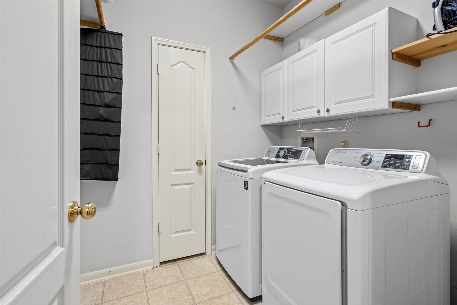 Functional laundry room with built-in cabinetry and shelving that provides valuable organization and storage. For buyers looking beyond cosmetic finishes, this is the kind of everyday utility that helps a home work efficiently for a busy household.