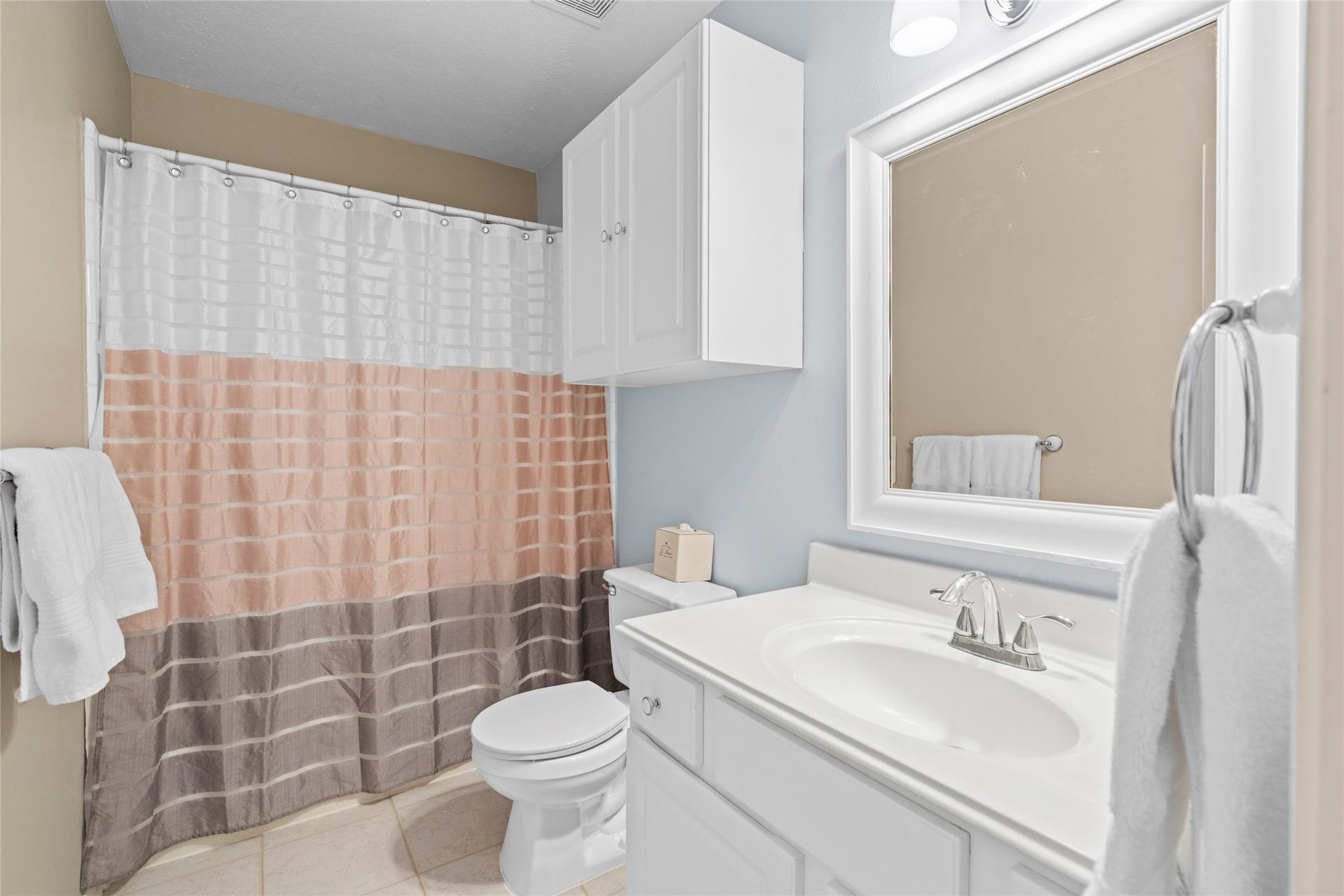 Bright secondary bathroom with generous vanity space, storage, and a clean, functional arrangement. The layout provides practical support for the home's additional bedrooms and family living spaces.