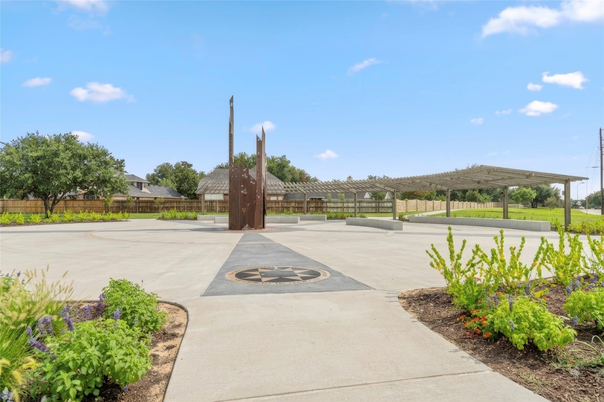 Freedom park with attractive landscaping, modern sculptures, and a covered pavilion that creates an inviting setting for gatherings and outdoor enjoyment. The nearby community amenities add lifestyle value beyond the home's property lines.