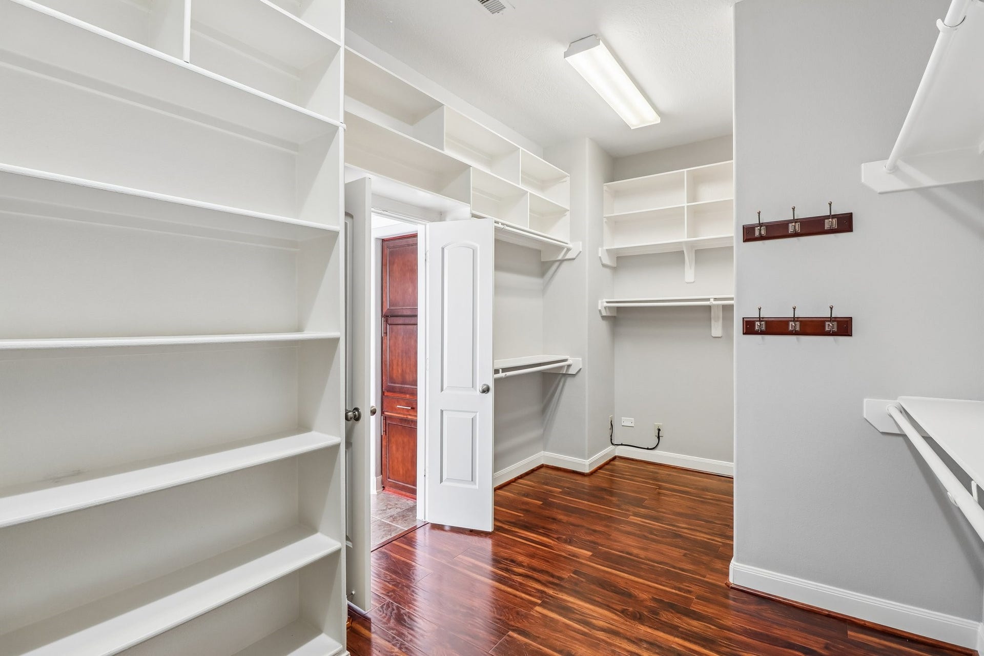 22715 Wilbur Lane, Tomball, TX 77375 Expansive walk-in closet featuring ample shelving and hanging space, complemented by elegant wood flooring.