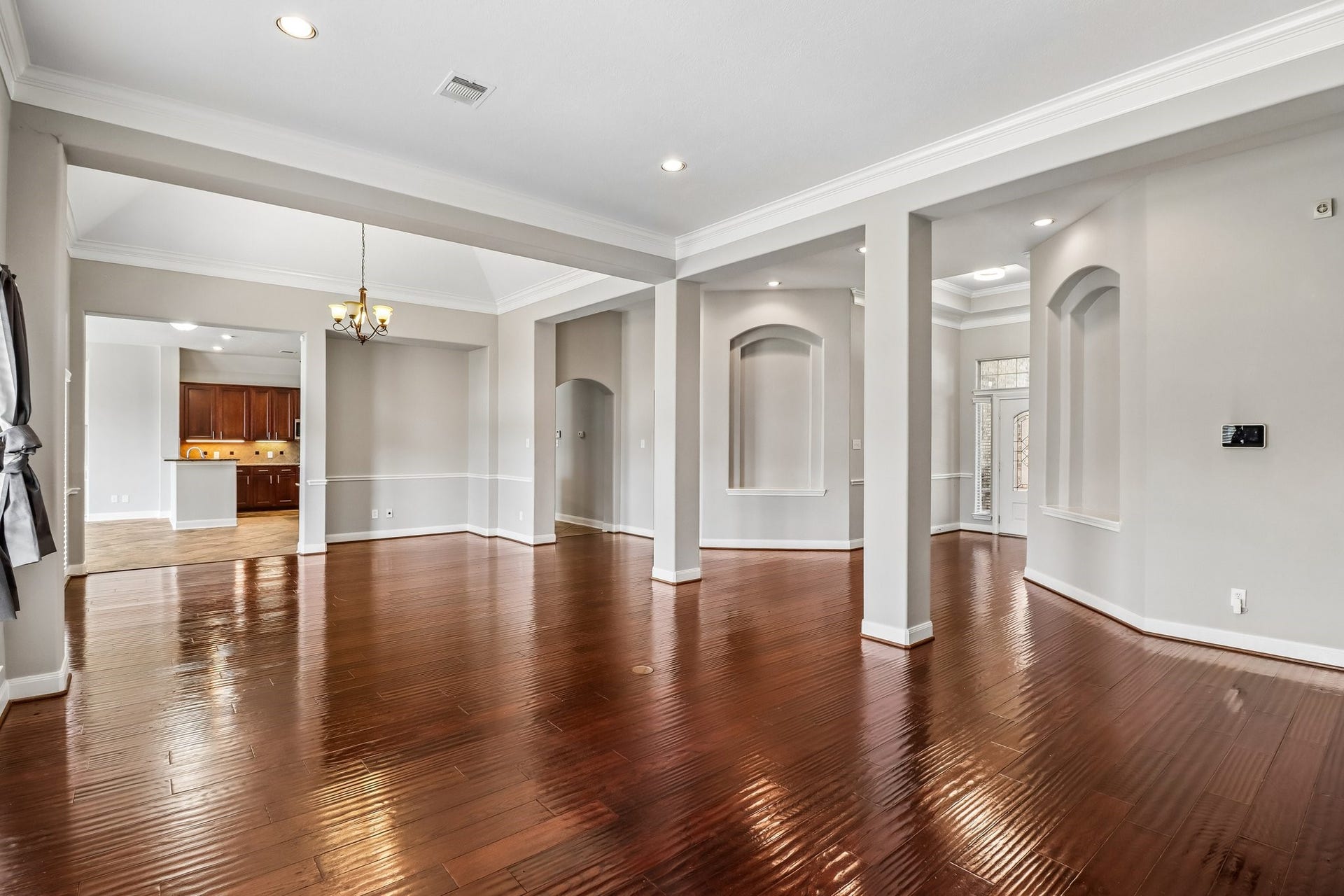 22715 Wilbur Lane, Tomball, TX 77375 Spacious open-concept living area with elegant hardwood floors, recessed lighting, and a view into the kitchen and dining room, perfect for entertaining.
