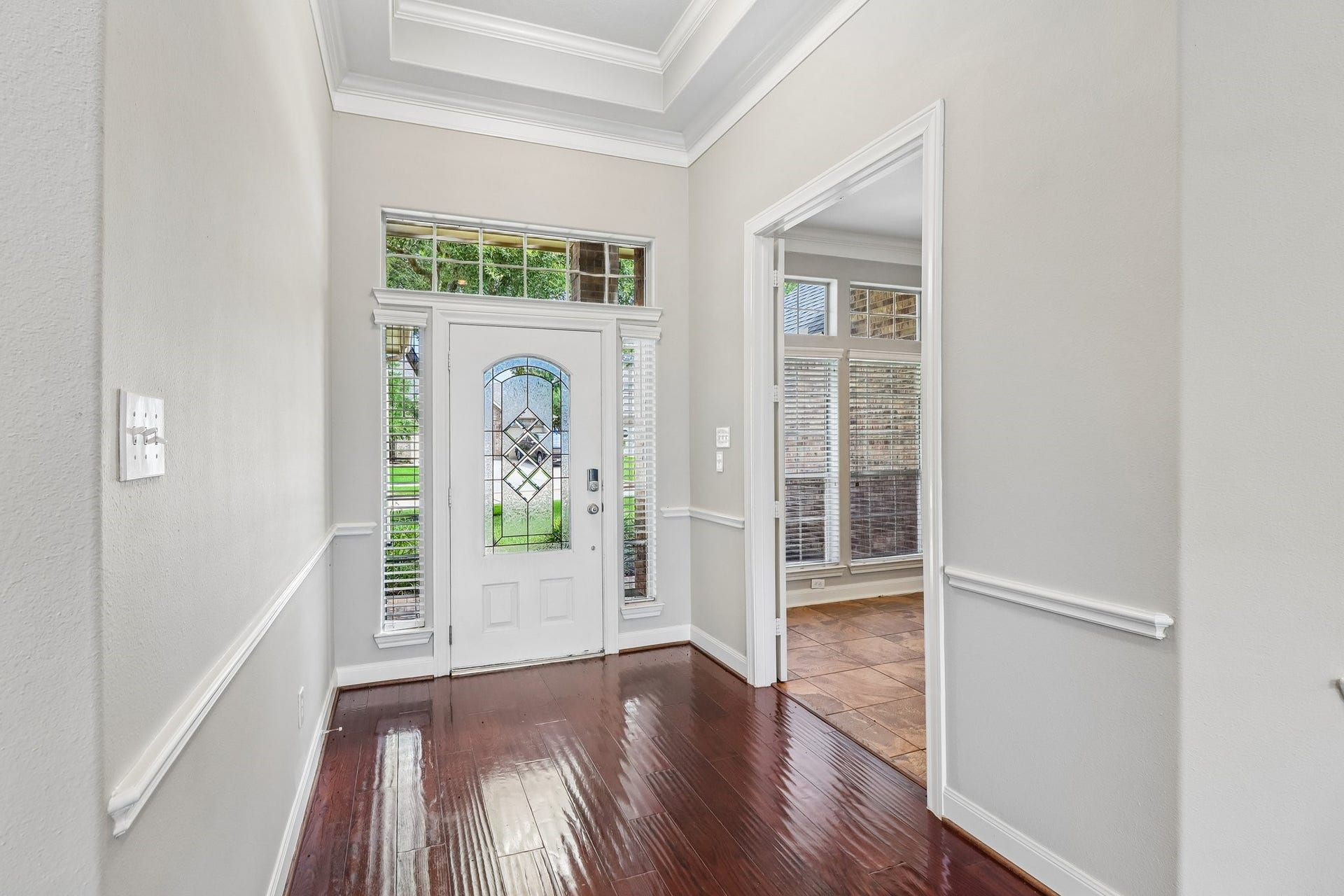 22715 Wilbur Lane, Tomball, TX 77375 Inviting entryway with elegant glass-paneled front door, gleaming hardwood floors, and abundant natural light.