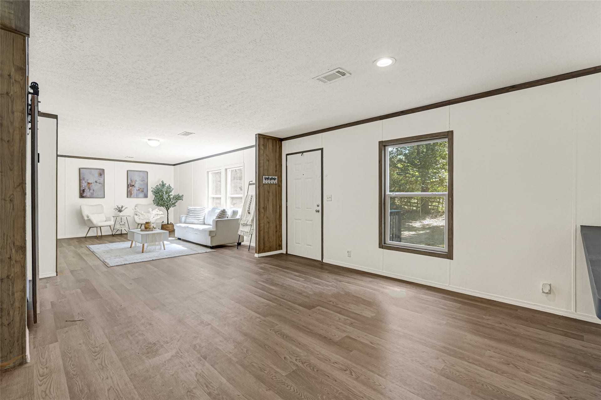 10506 Settlers Crossing, Conroe, TX 77303 Spacious living area with elegant wood flooring, abundant natural light from large windows.