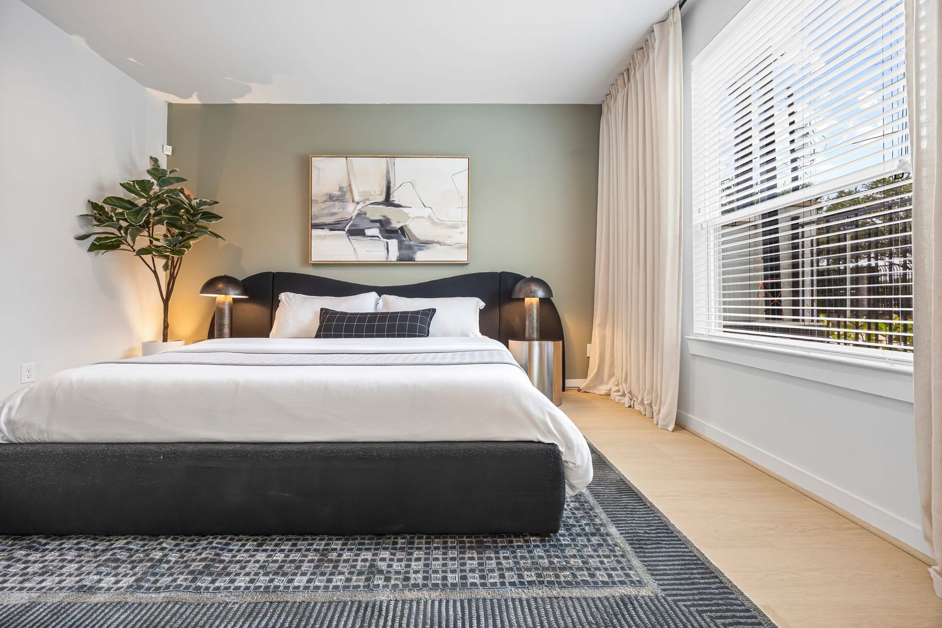 Experience ultimate relaxation in this inviting guest suite, featuring a plush bed, stylish decor, and abundant natural light streaming through large windows. **Model Home of similar layout & finishes.**