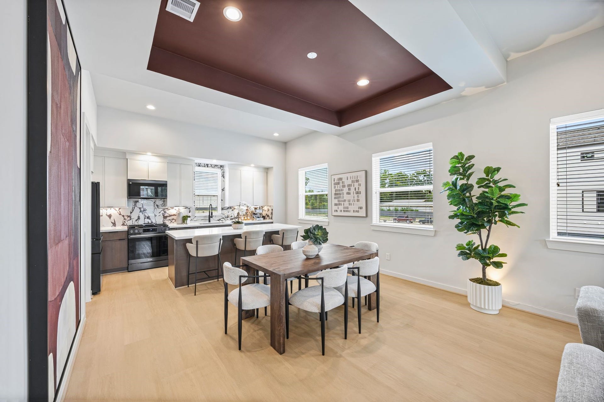 Experience modern elegance with this open-concept dining and kitchen area, featuring sleek design elements, ample natural light, and a perfect space for entertaining. **Model Home of similar layout & finishes.**
