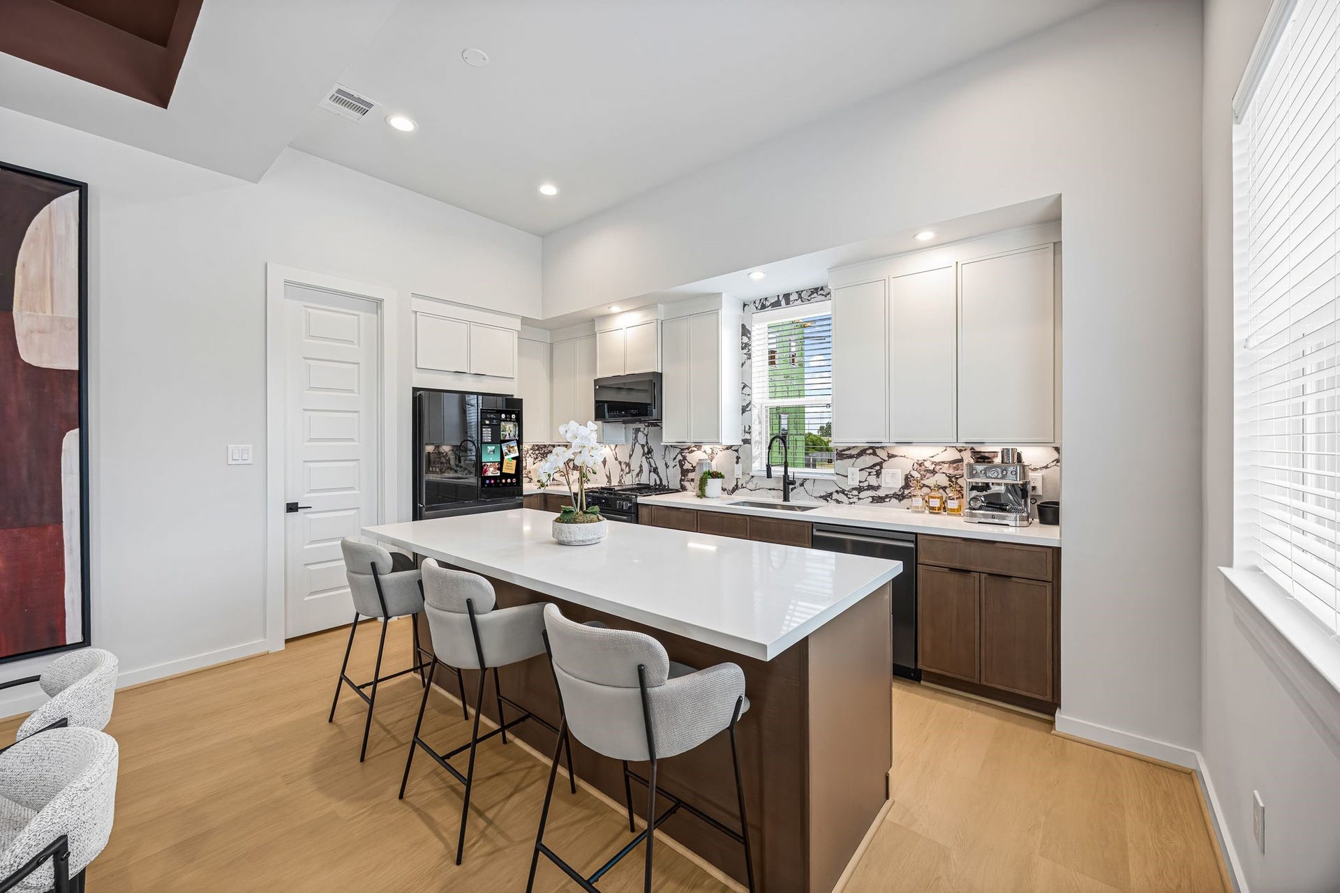 A modern kitchen featuring sleek cabinetry, a spacious island with seating, and stylish countertops, perfect for both casual dining and entertaining. **Model Home of similar layout & finishes.**