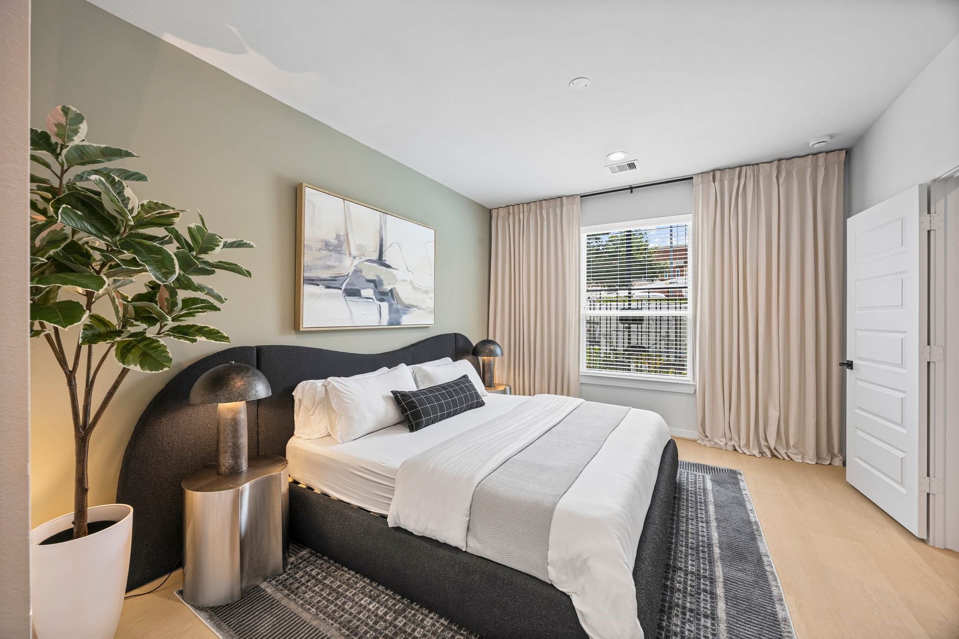 Experience ultimate relaxation in this stylish guest suite, featuring a plush bed, modern accents, and abundant natural light. **Model Home of similar layout & finishes.**