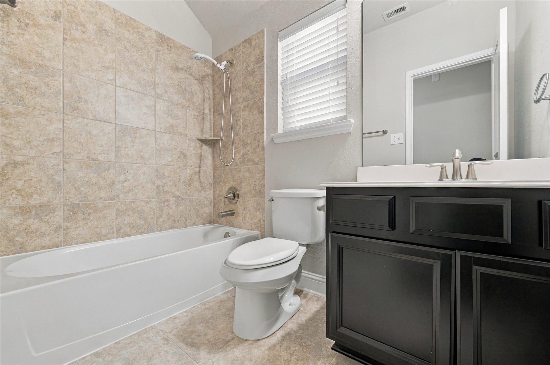 8119 W Pine Creek Bend, Cypress, TX 77433 The secondary bathroom offers a sink with cabinet for storage, and combo tub and show.