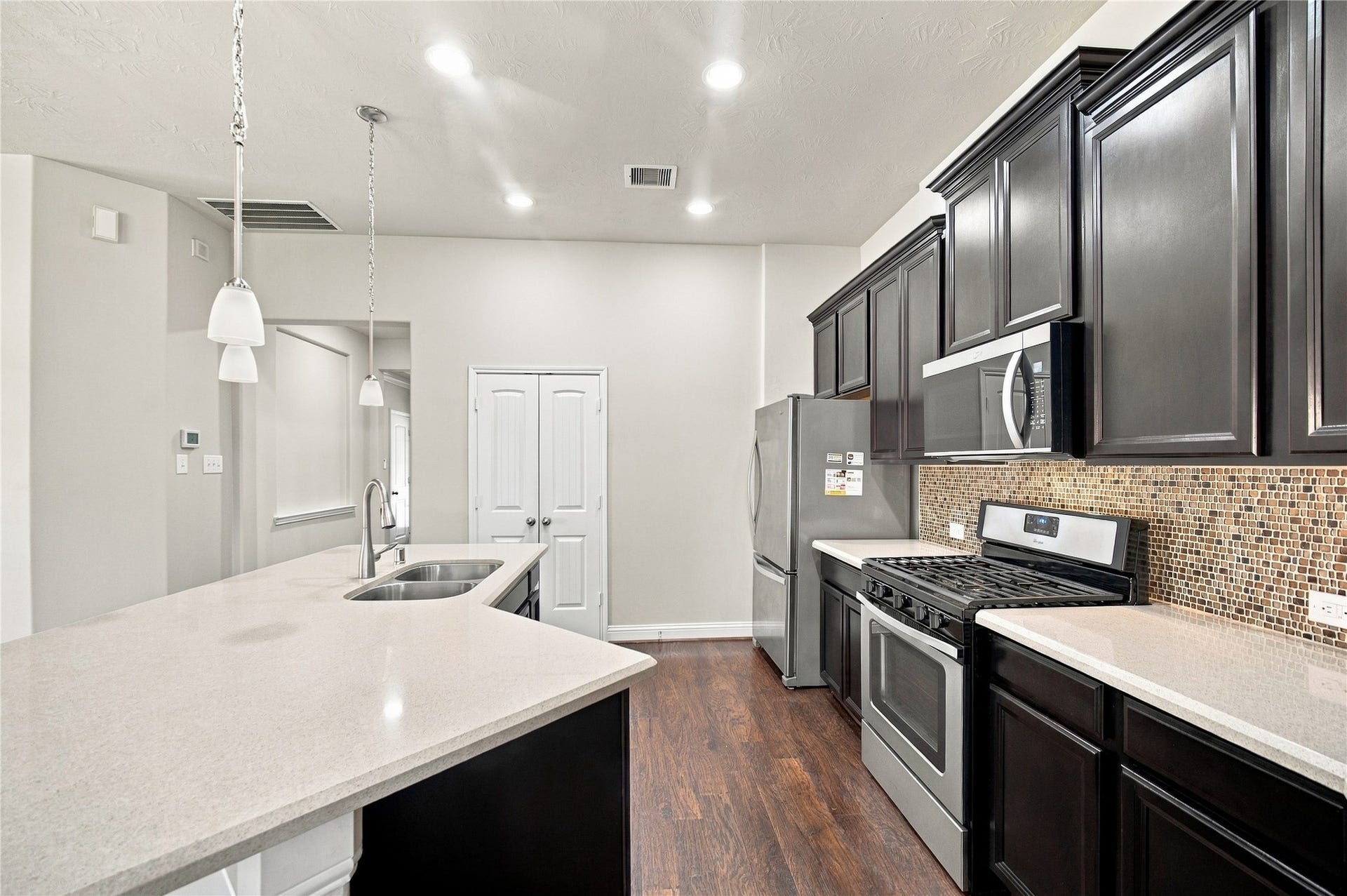 8119 W Pine Creek Bend, Cypress, TX 77433 Pendant and recessed lighting add the perfect finishing touches to the kitchen.