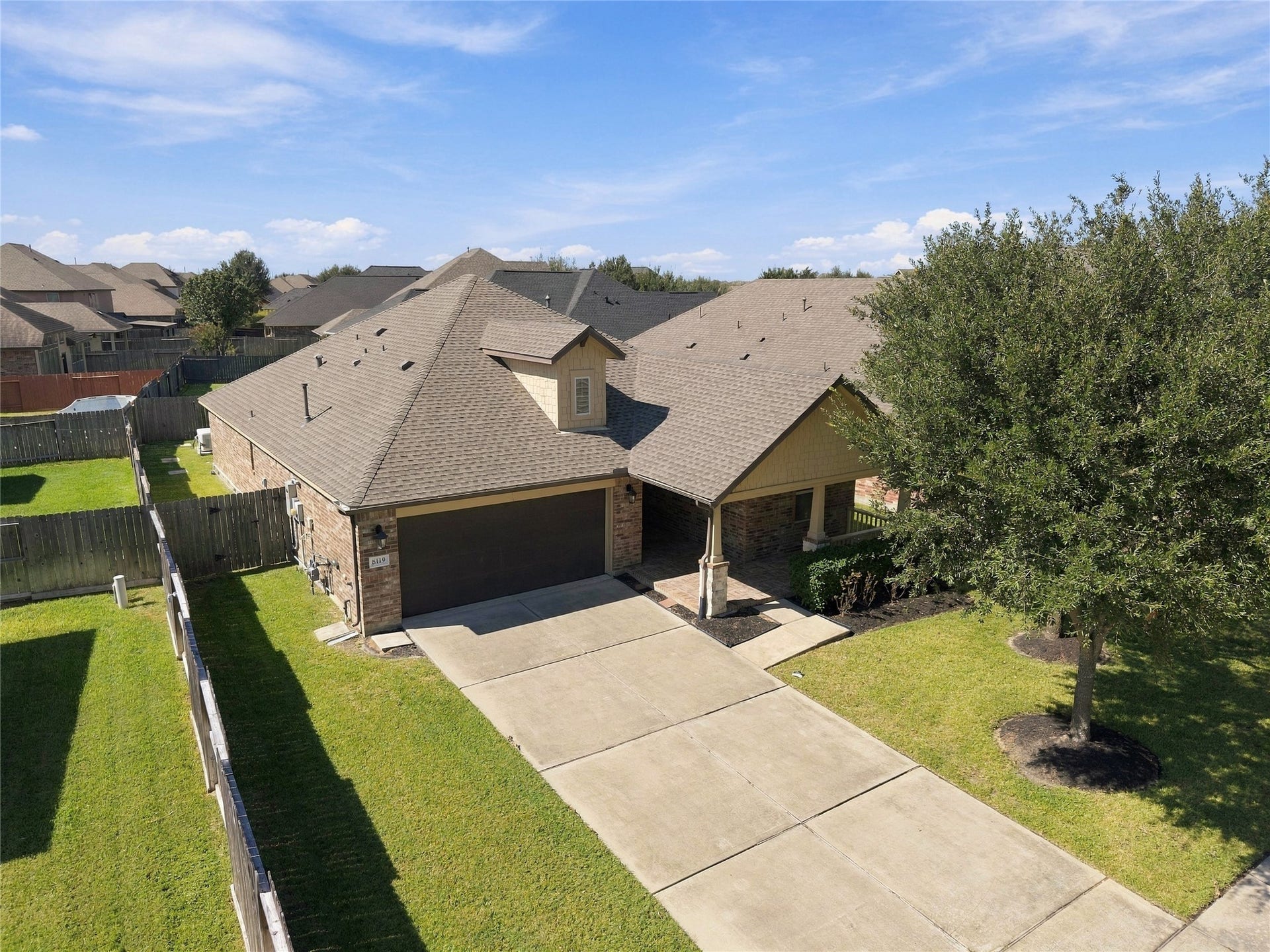 8119 W Pine Creek Bend, Cypress, TX 77433 The aerial birds-eye view offers a unique perspective of the home, showcasing its roofline, and landscaping, driveway.