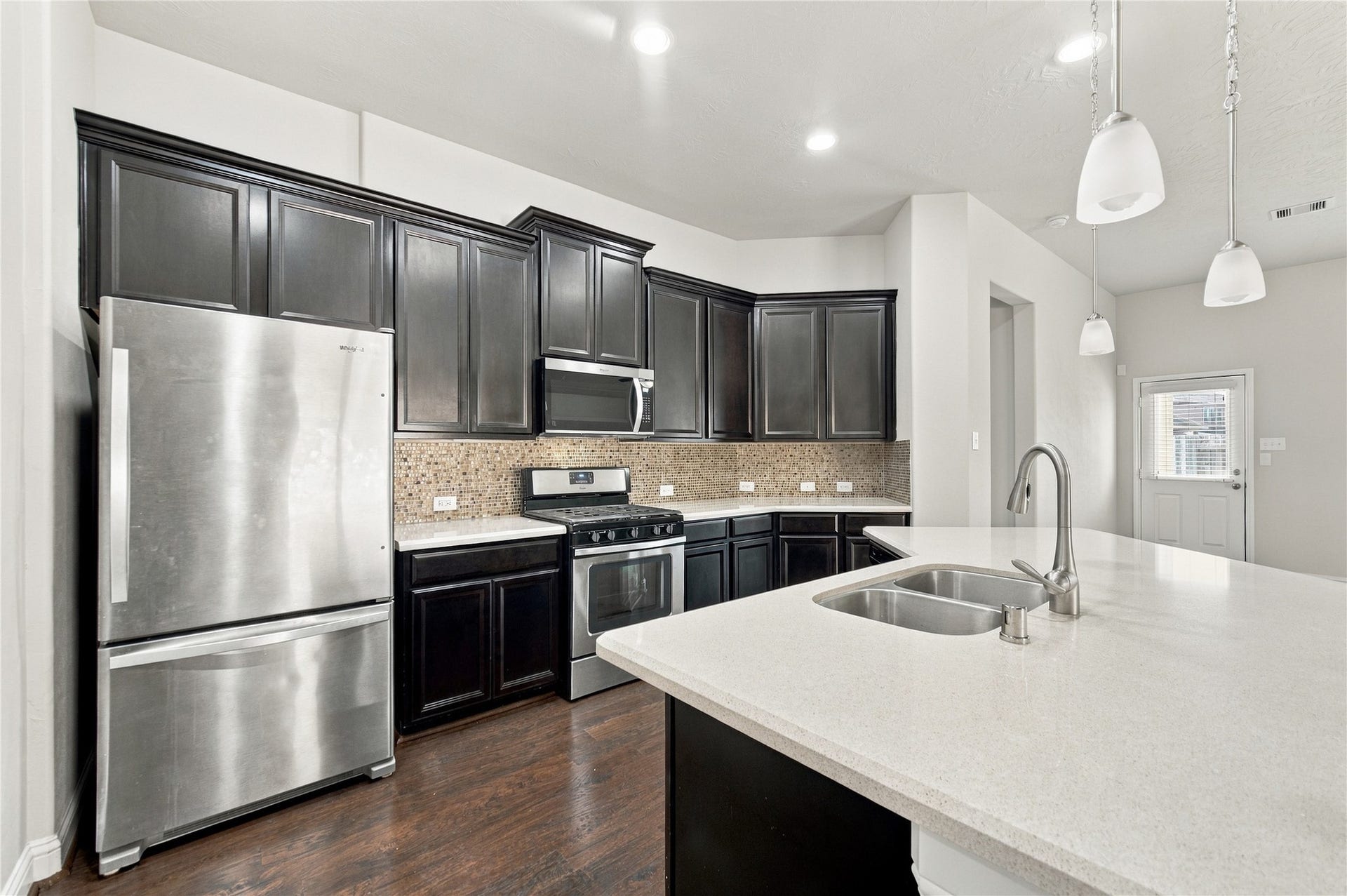 8119 W Pine Creek Bend, Cypress, TX 77433 The kitchen features stainless steel appliances, rich espresso-colored maple cabinetry, elegant Silestone countertops, and beautiful tile backsplash. kitchen complete with stainless steel appliances, rich espresso-colored maple cabinetry, elegant Silestone countertops, and beautiful tile backsplash.