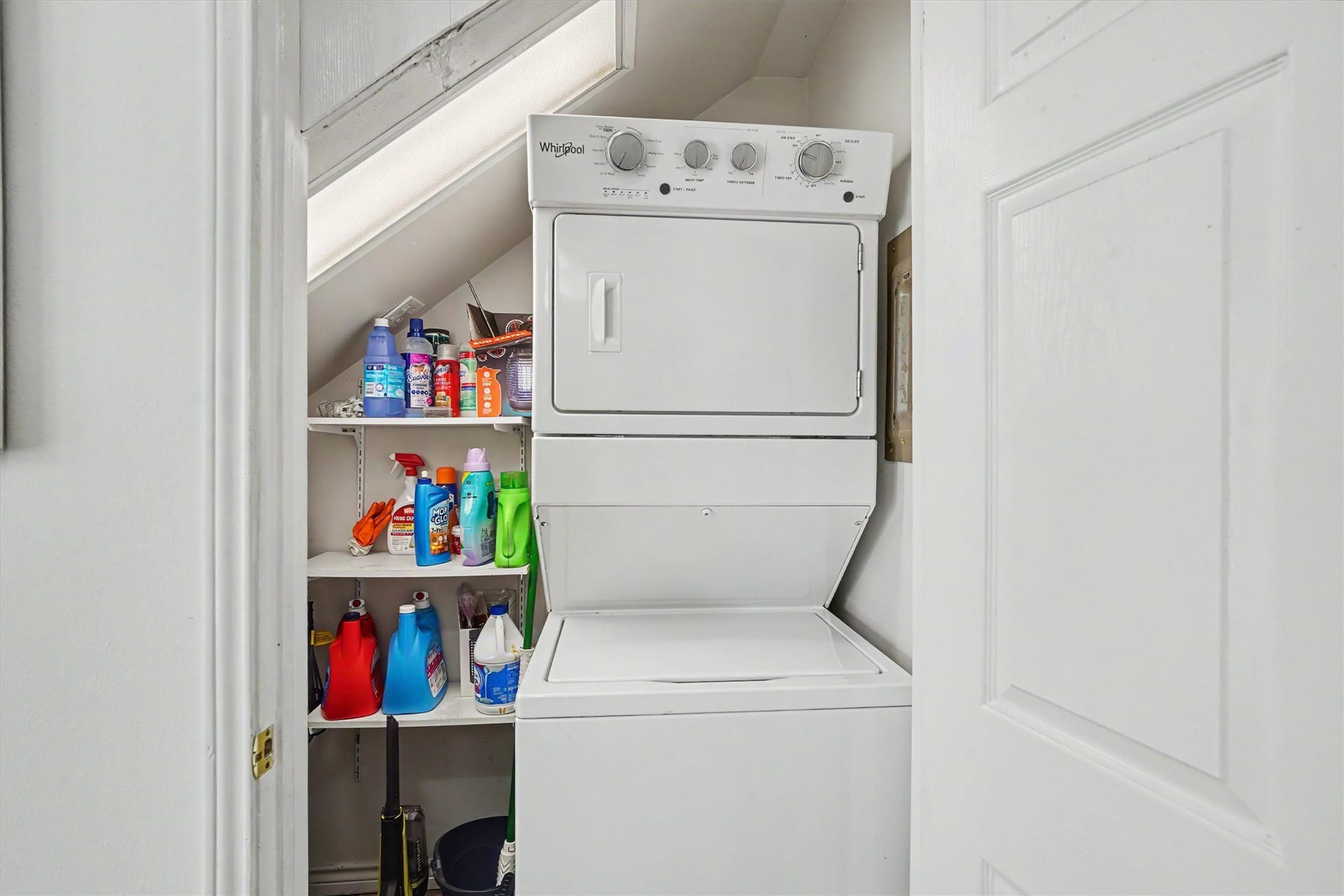 The laundry room includes storage shelves