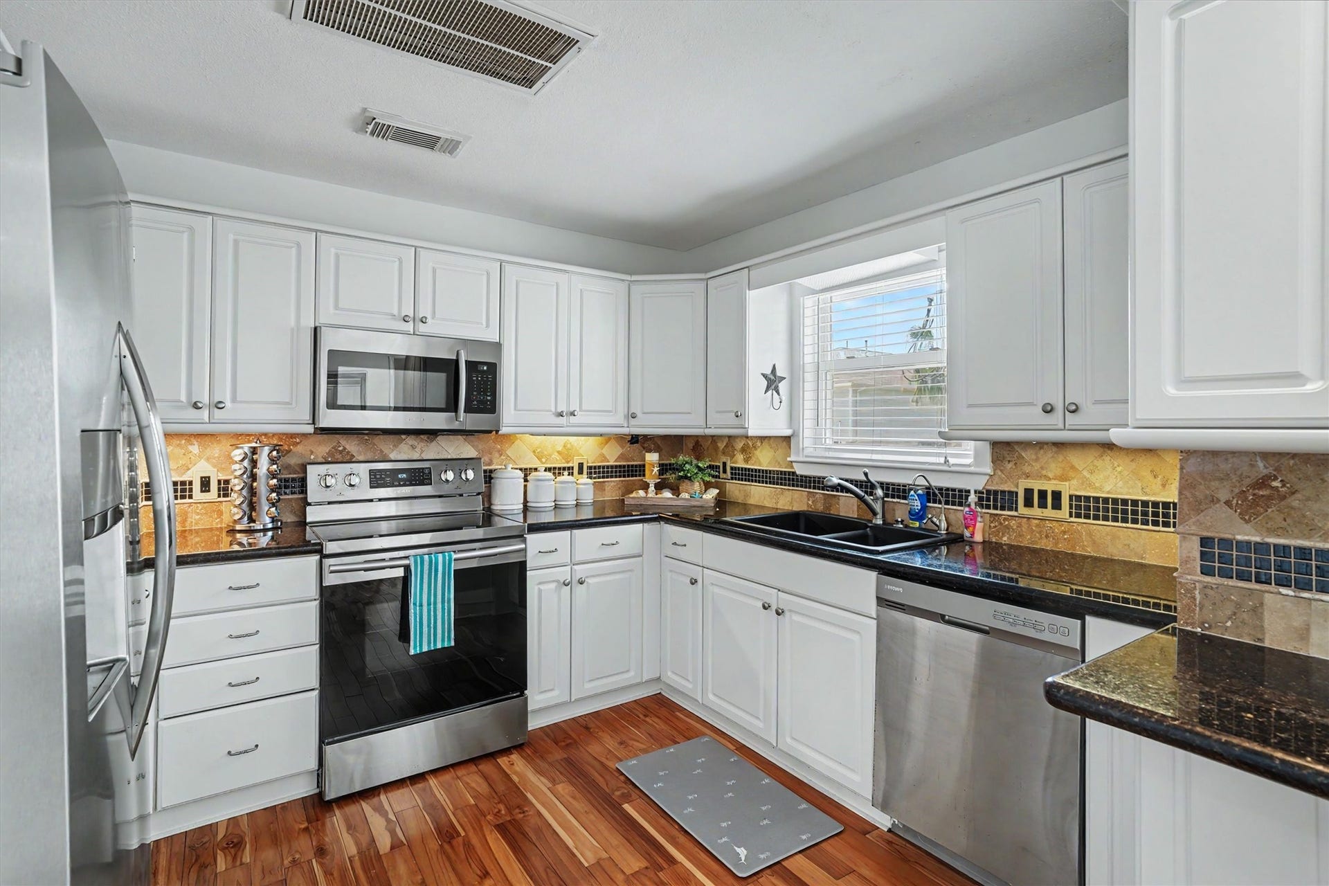 The white kitchen has been updated with granite, backsplash and stainless appliances. The under cabinet lighting provides a nice touch to any kitchen
